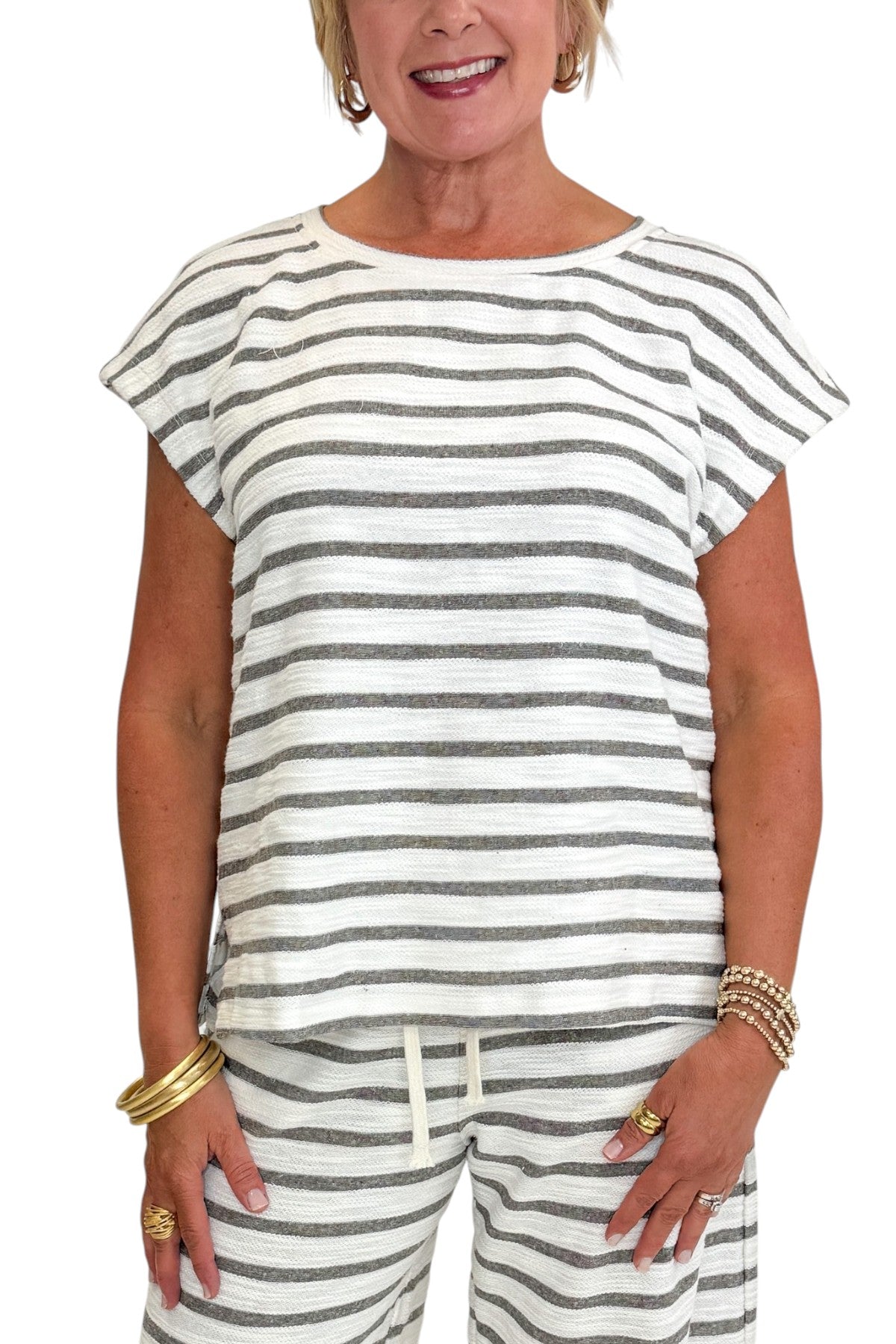 Front detail view of woman wearing Swagger Boutiqueβs Light Grey Striped Short Sleeve Top with matching Light Grey Striped Lounge Pants against white studio background.