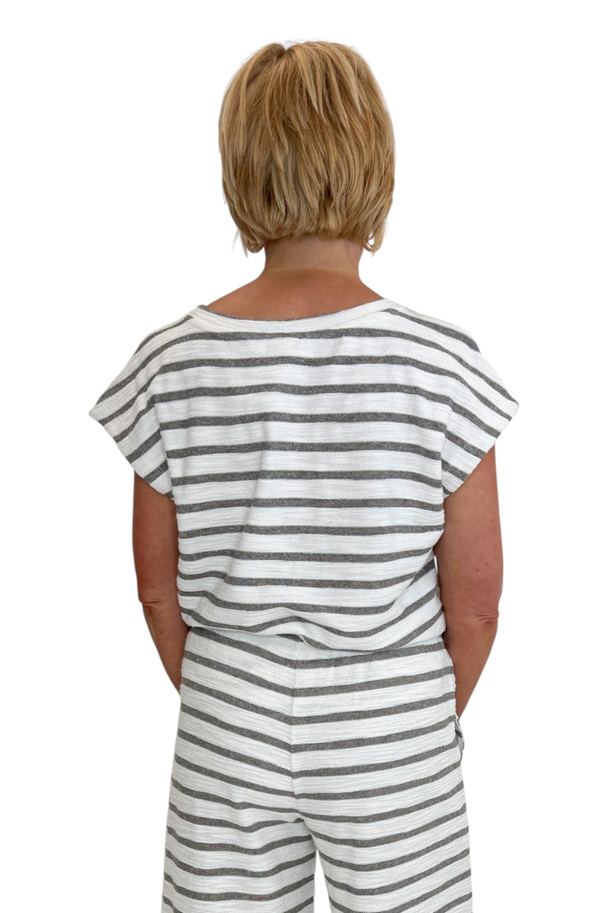 Back view of woman wearing Swagger Boutiqueβs Light Grey Striped Short Sleeve Top with matching Light Grey Striped Lounge Pants against white studio background.