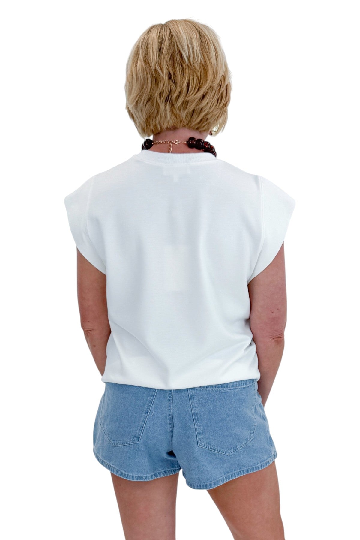 Back view of woman wearing Light Wash Denim Wrap Skort with white top against white studio background.