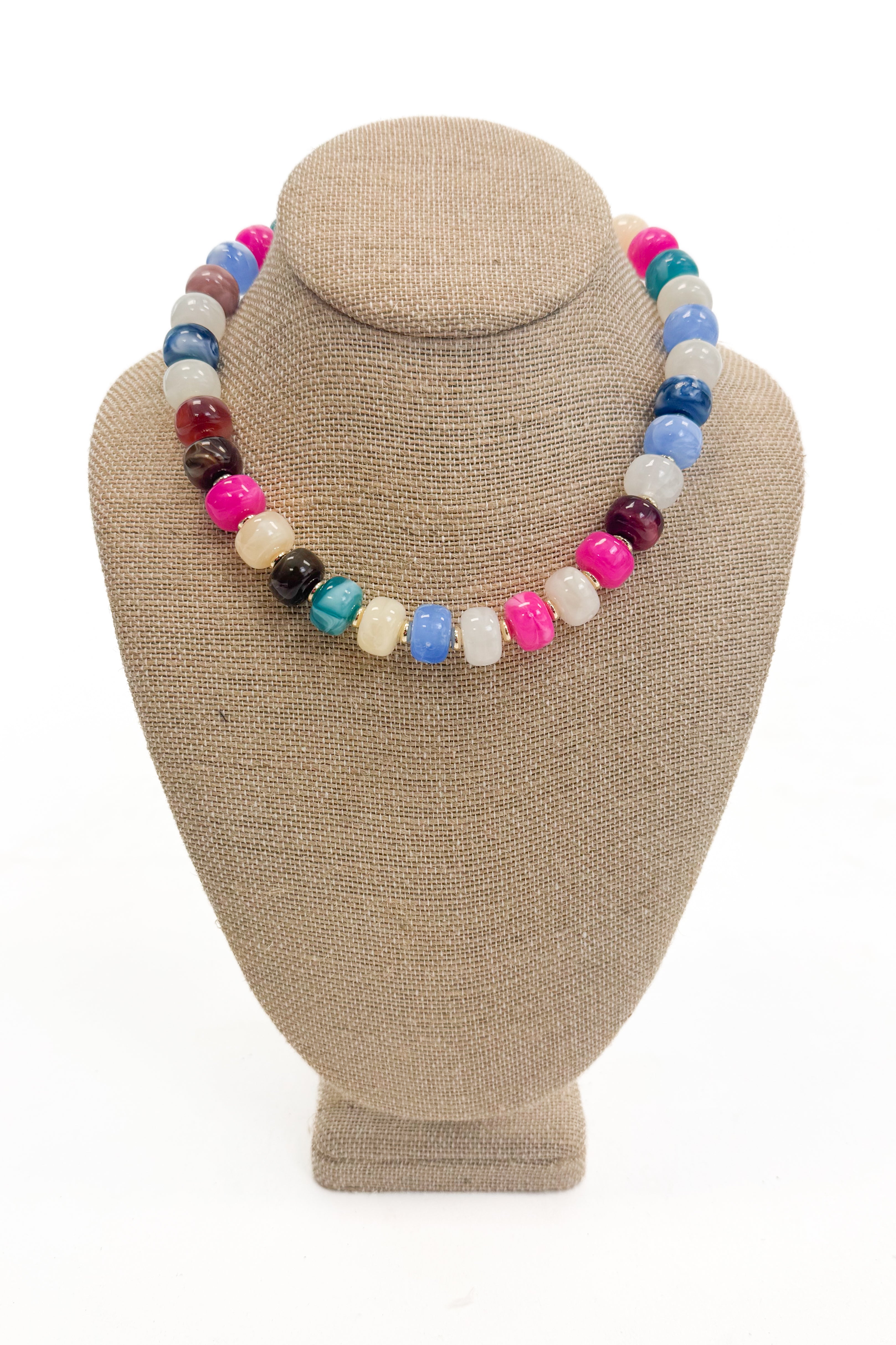 Colorful beaded necklace on a beige mannequin bust against a white background