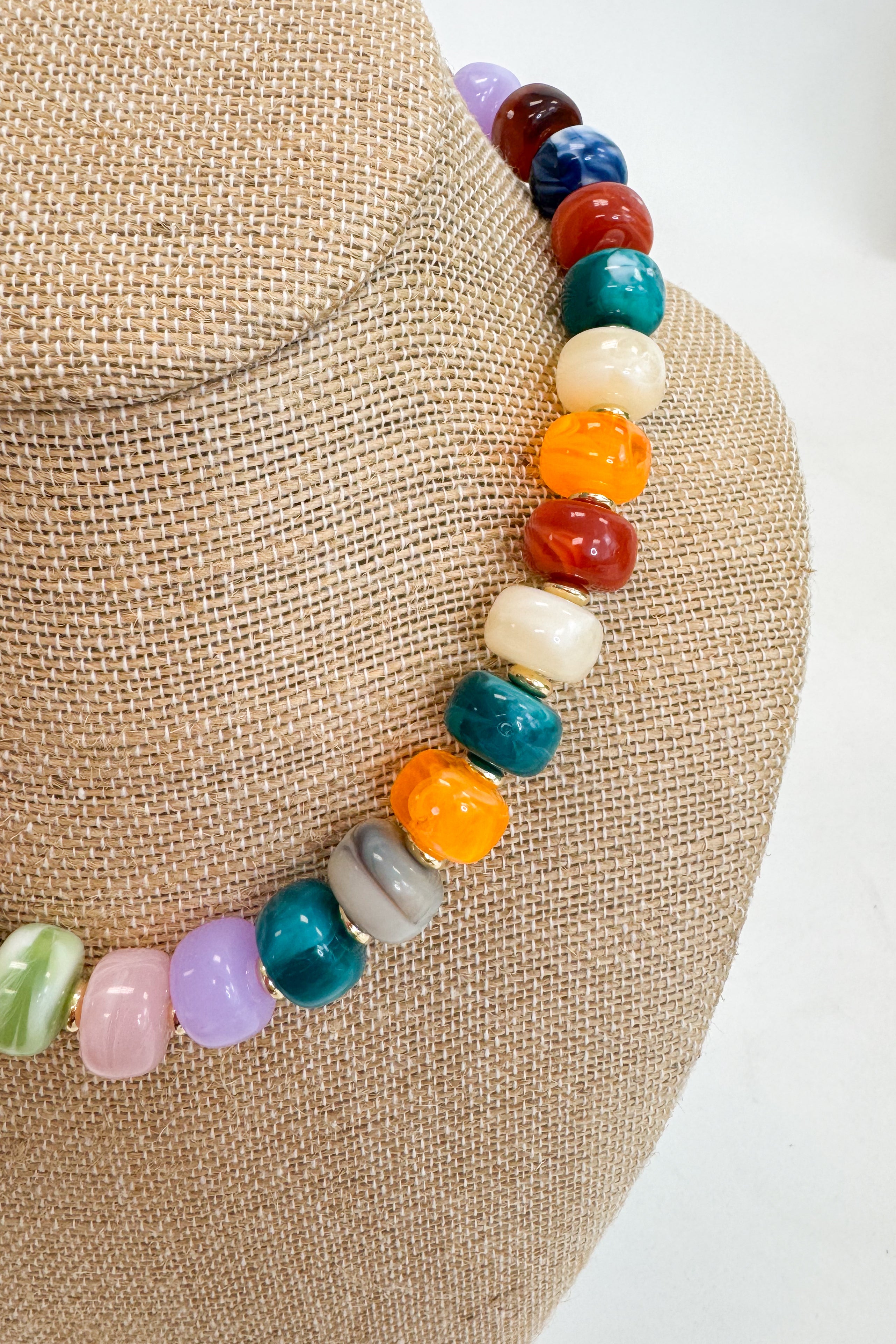 Necklace with multicolored beads on a textured surface