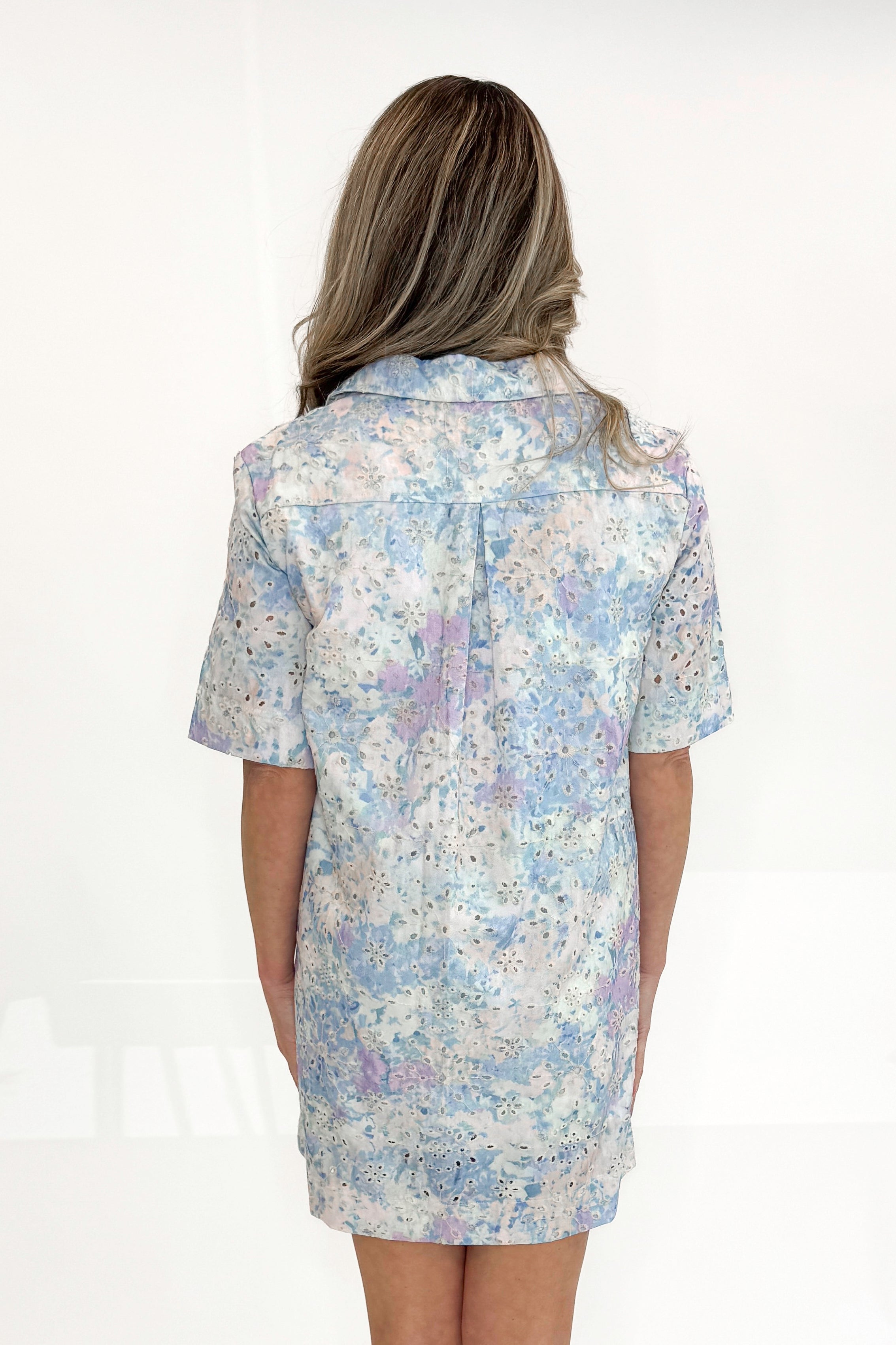 Back view of woman wearing Blue and Multi Eyelet Collared Dress with sandals against white studio background.