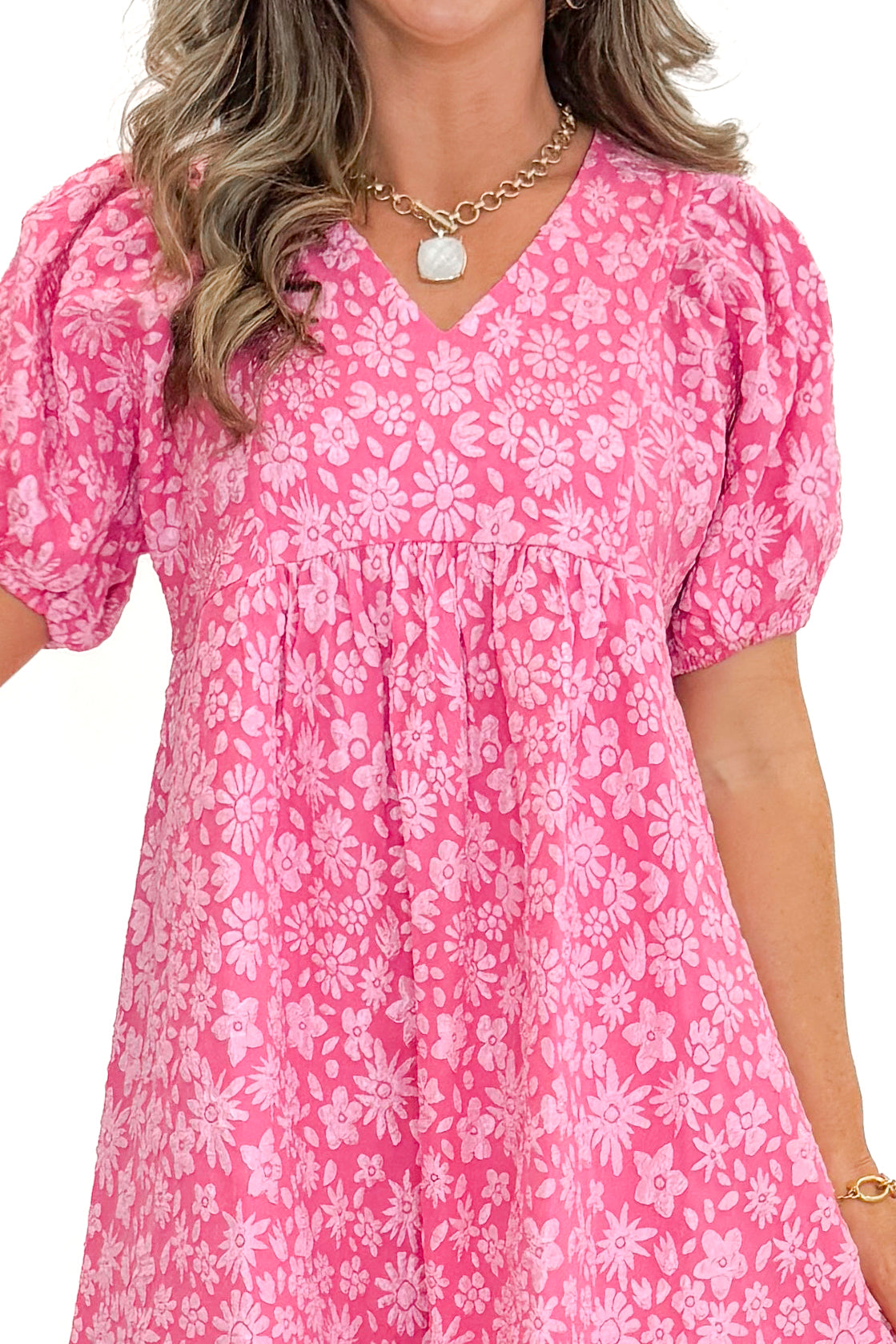 Front detail view of woman wearing Pink Floral Textured Puff Sleeve Midi Dress against white studio background.
