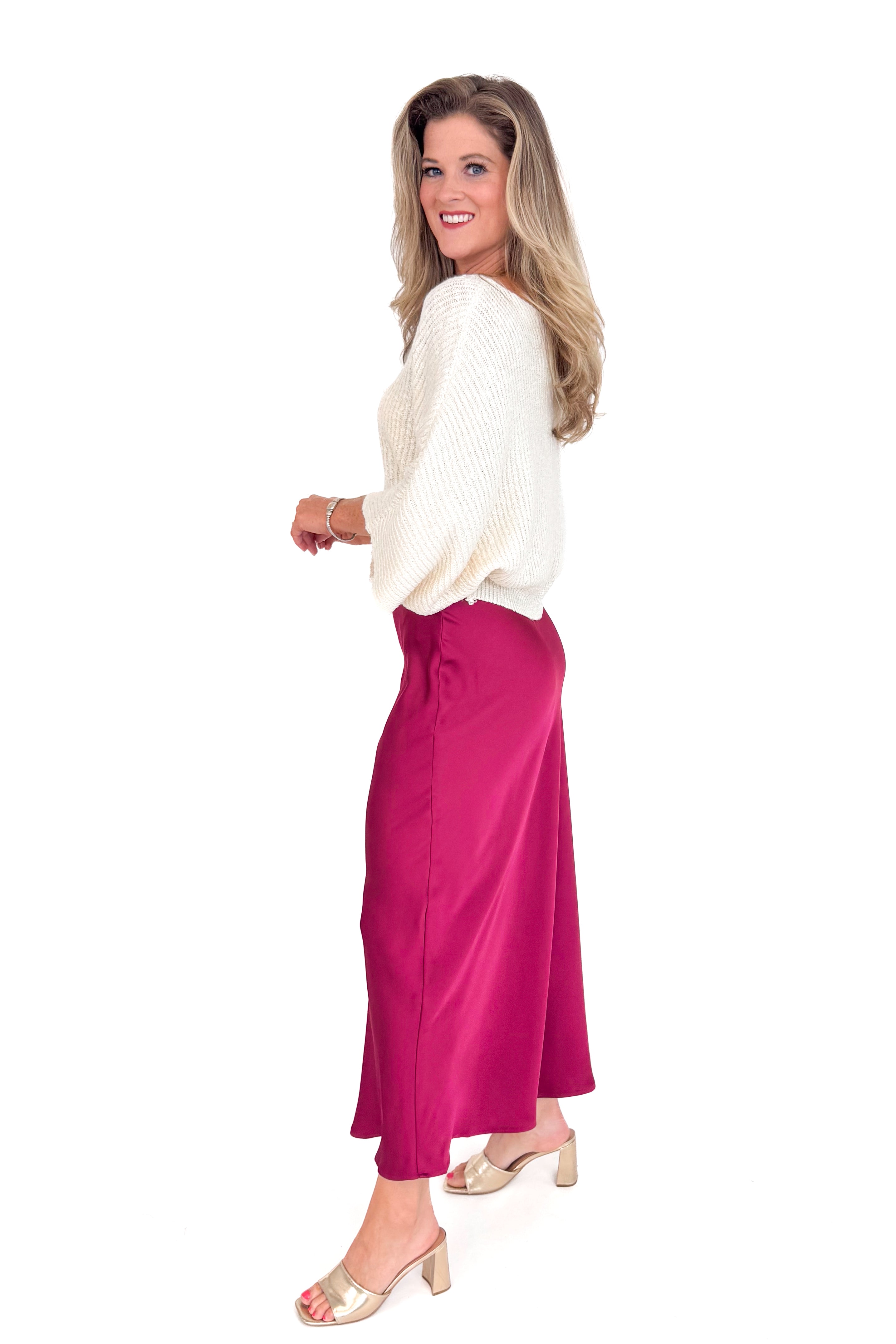 Woman wearing a white blouse and burgundy skirt on a white background