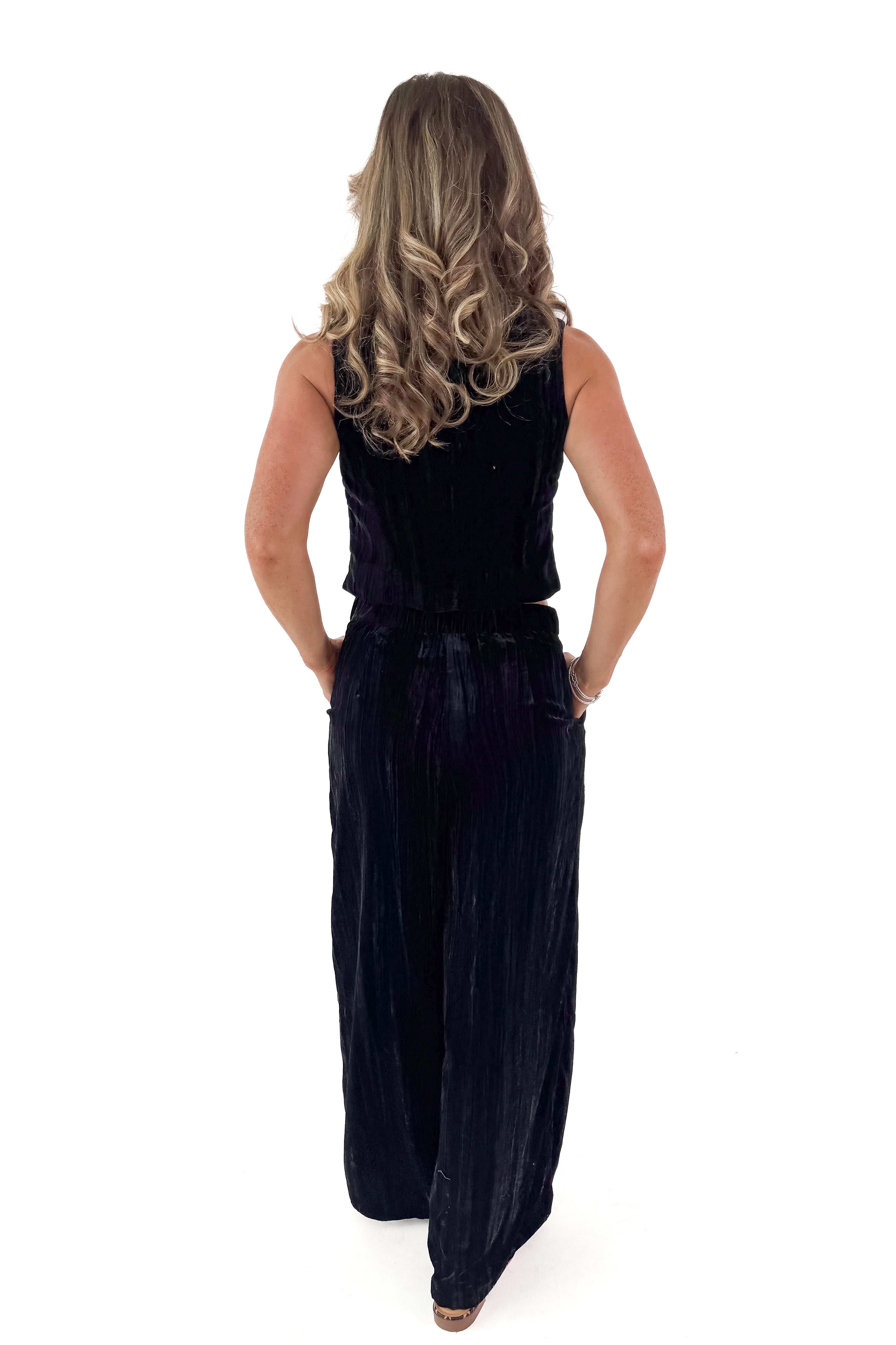 Back view of woman wearing Velvet V-neck Vest with matching pants against white studio background.
