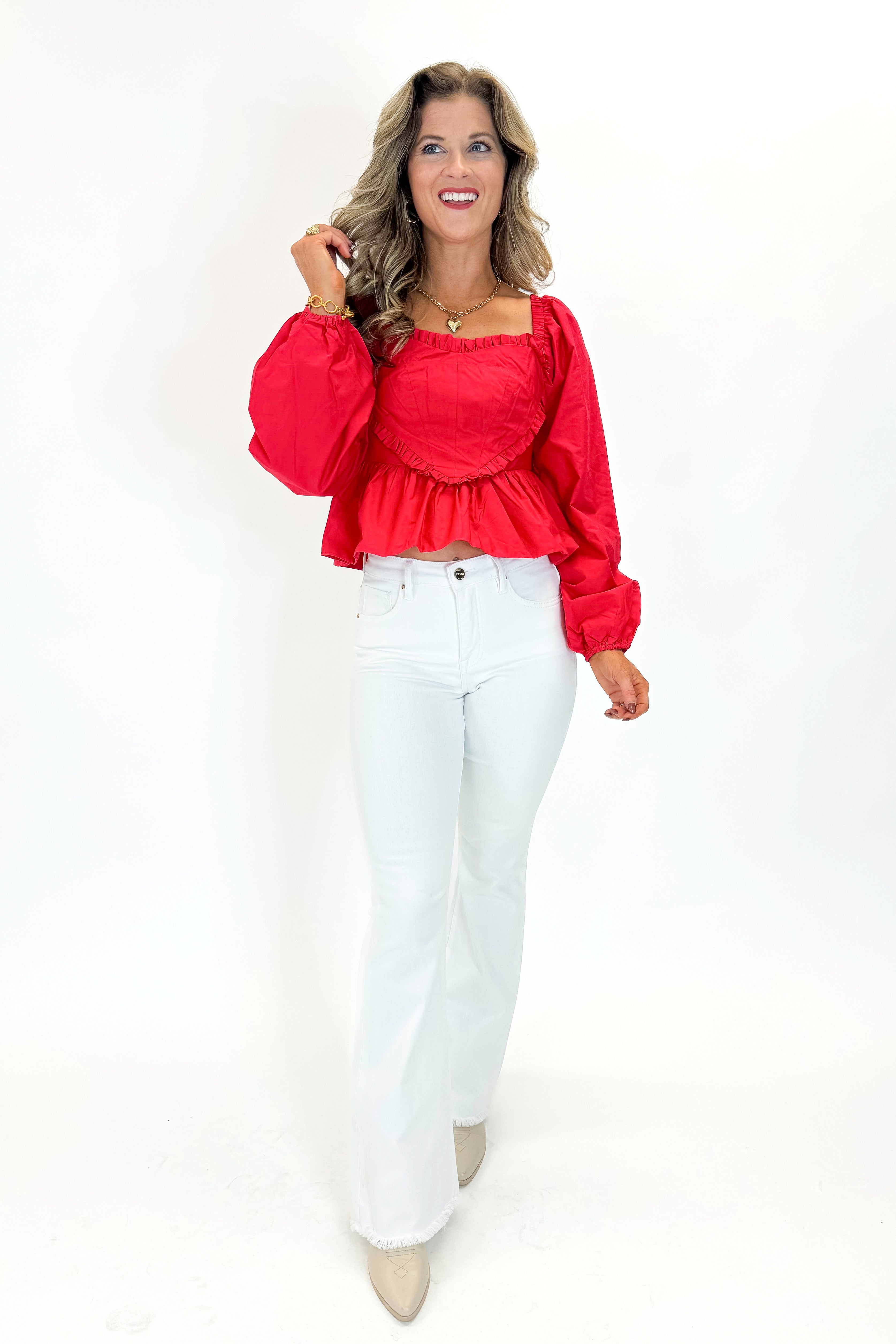 Front view of woman wearing Red Heart Detail Ruffle Top with jeans against white studio background.