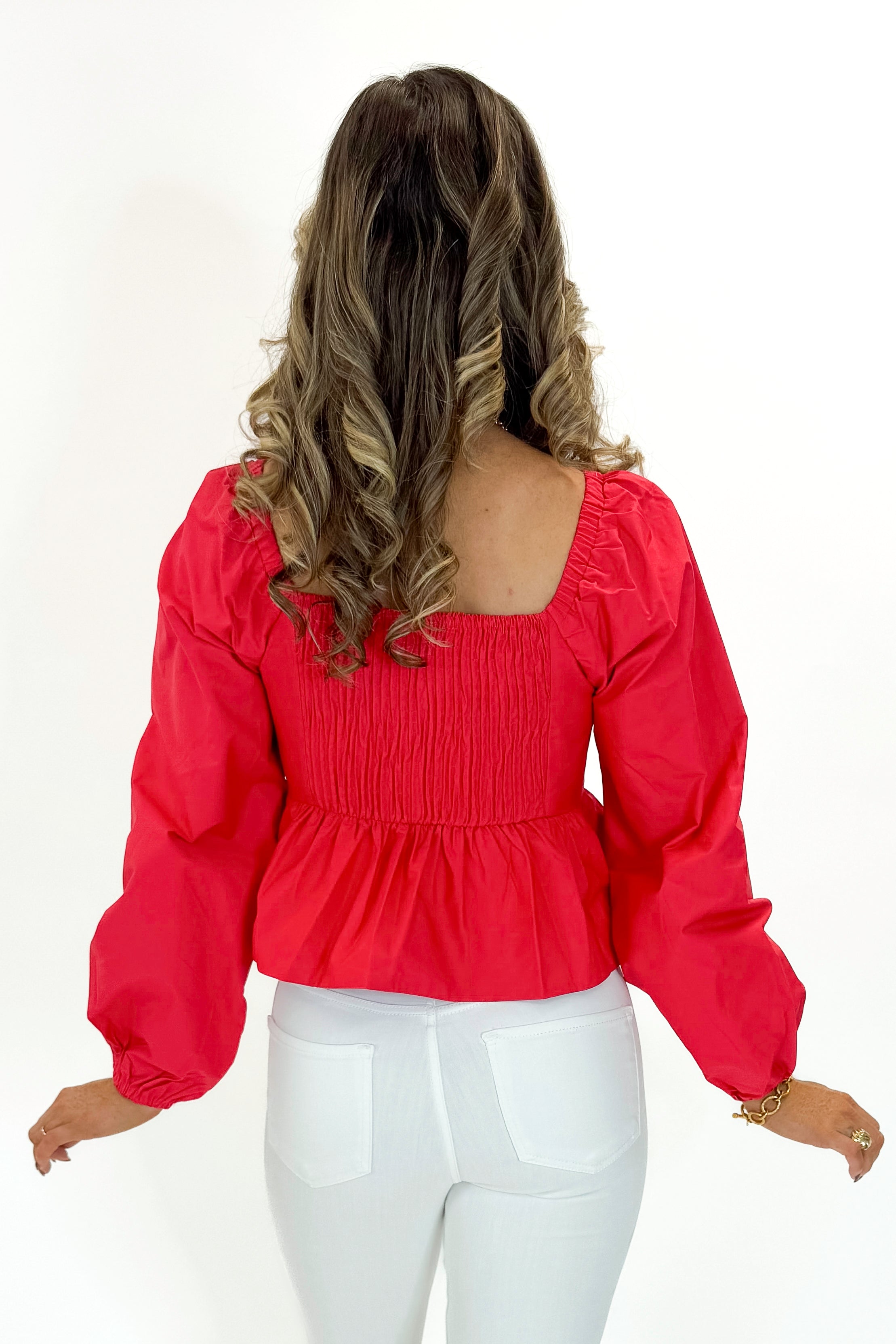 Back view of woman wearing Red Heart Detail Ruffle Top with jeans against white studio background.