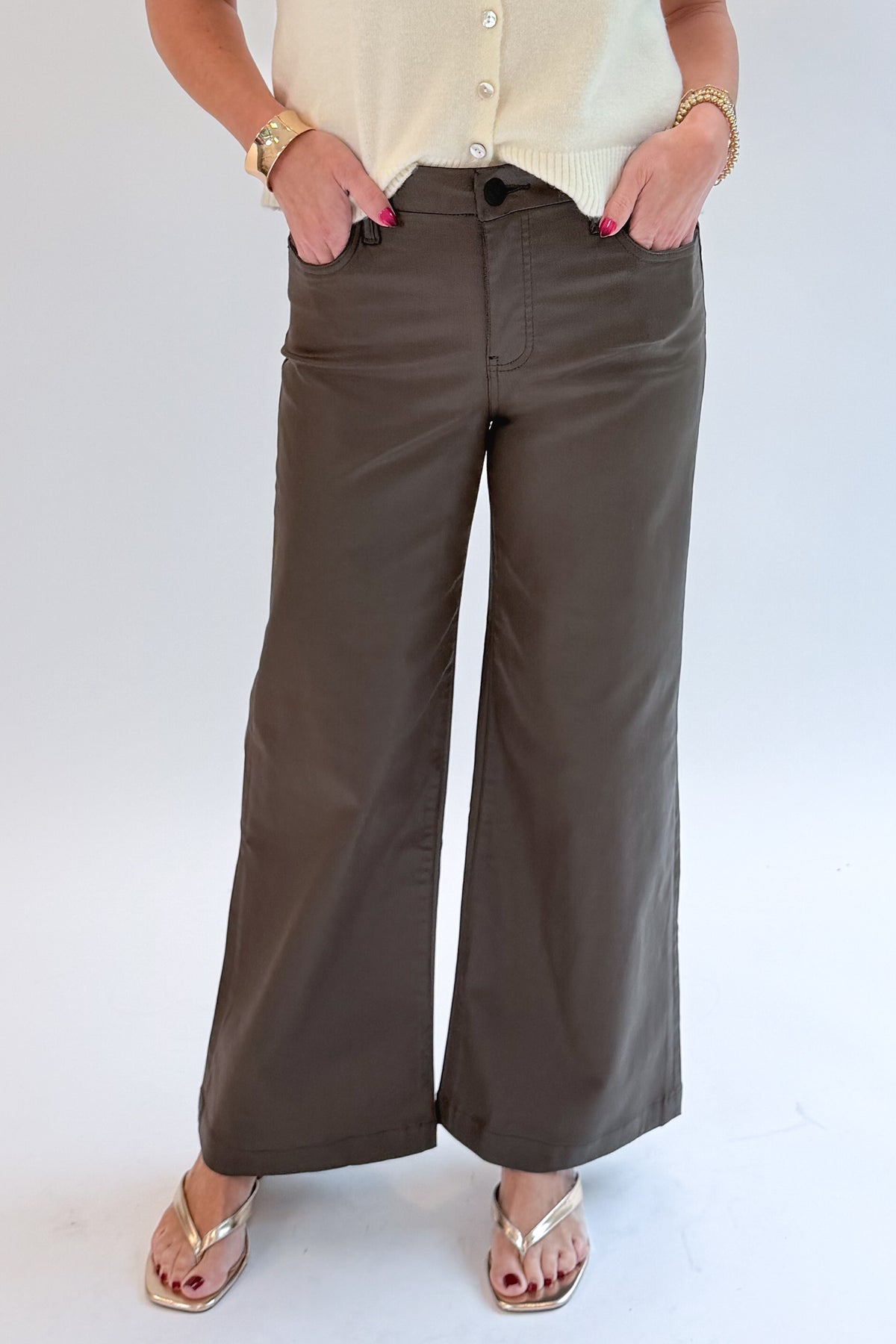 Front view of woman wearing Swagger Boutique’s sweater with Meg Coated Wide Leg Jeans in Toffee by Kut from the Kloth against white studio background.