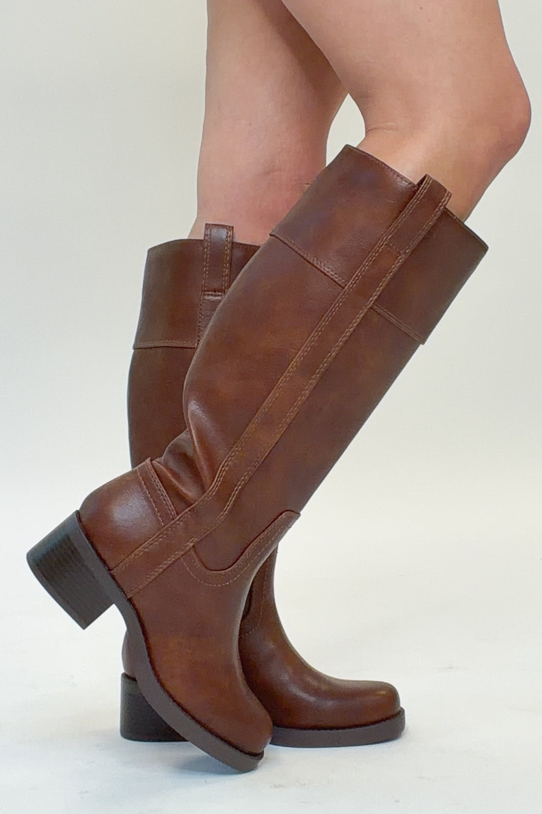 Mizell- Brown Tall Boots against white studio background side view.