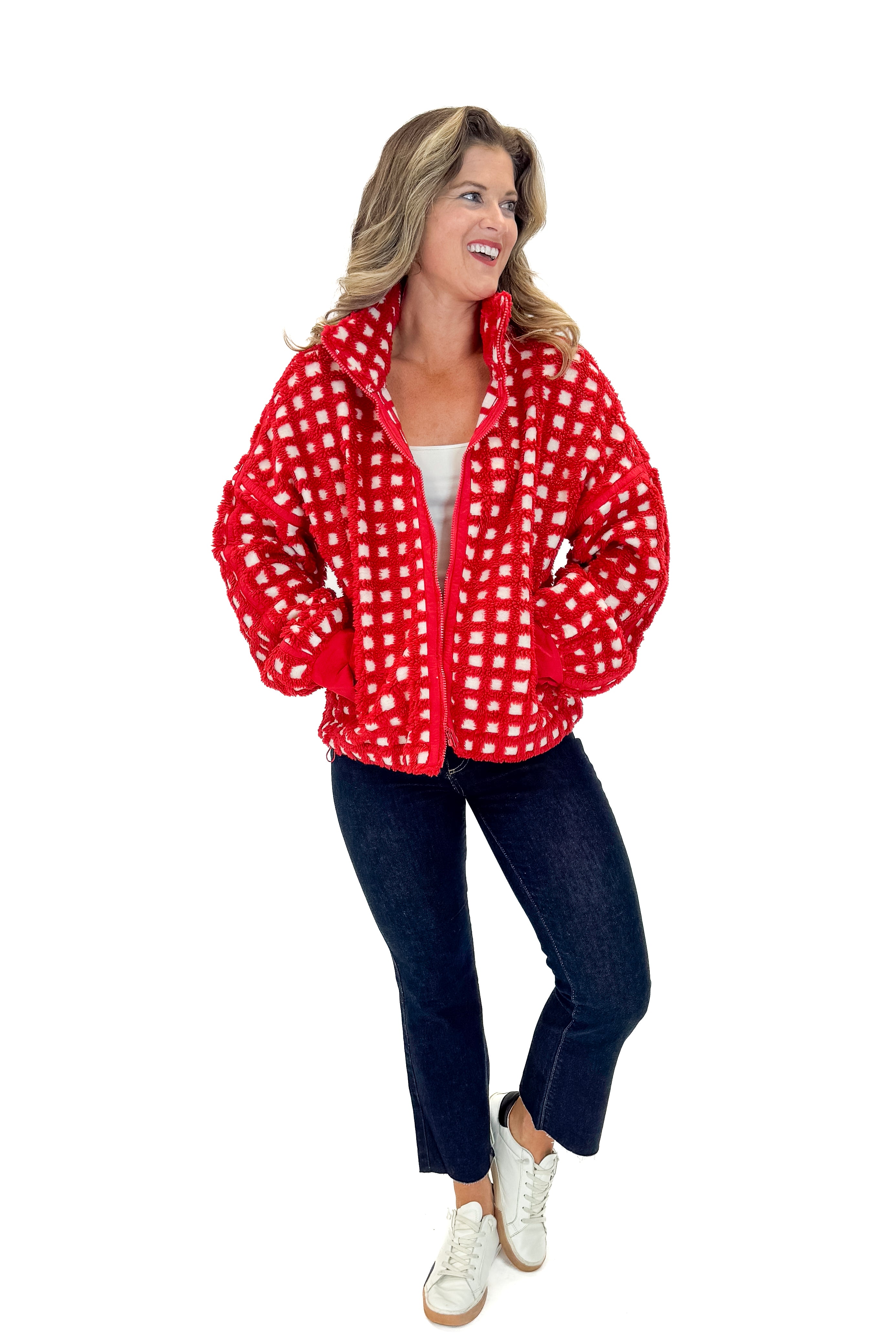 Front view of woman wearing Red & Cream Checkered Sherpa Jacket with jeans against white studio background.