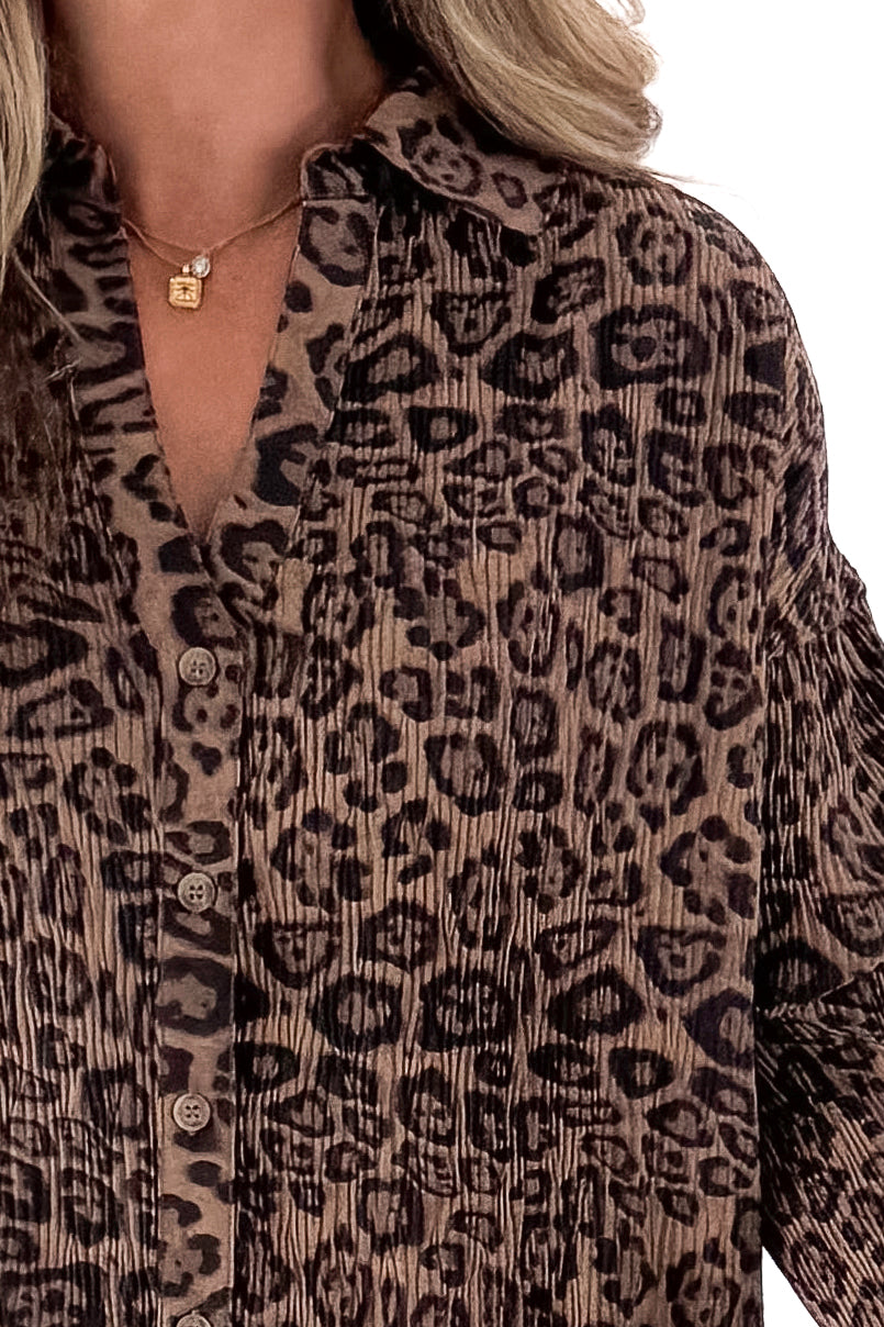 Front detailed view of woman wearing Leopard Pleated Button Up Top against white studio background.