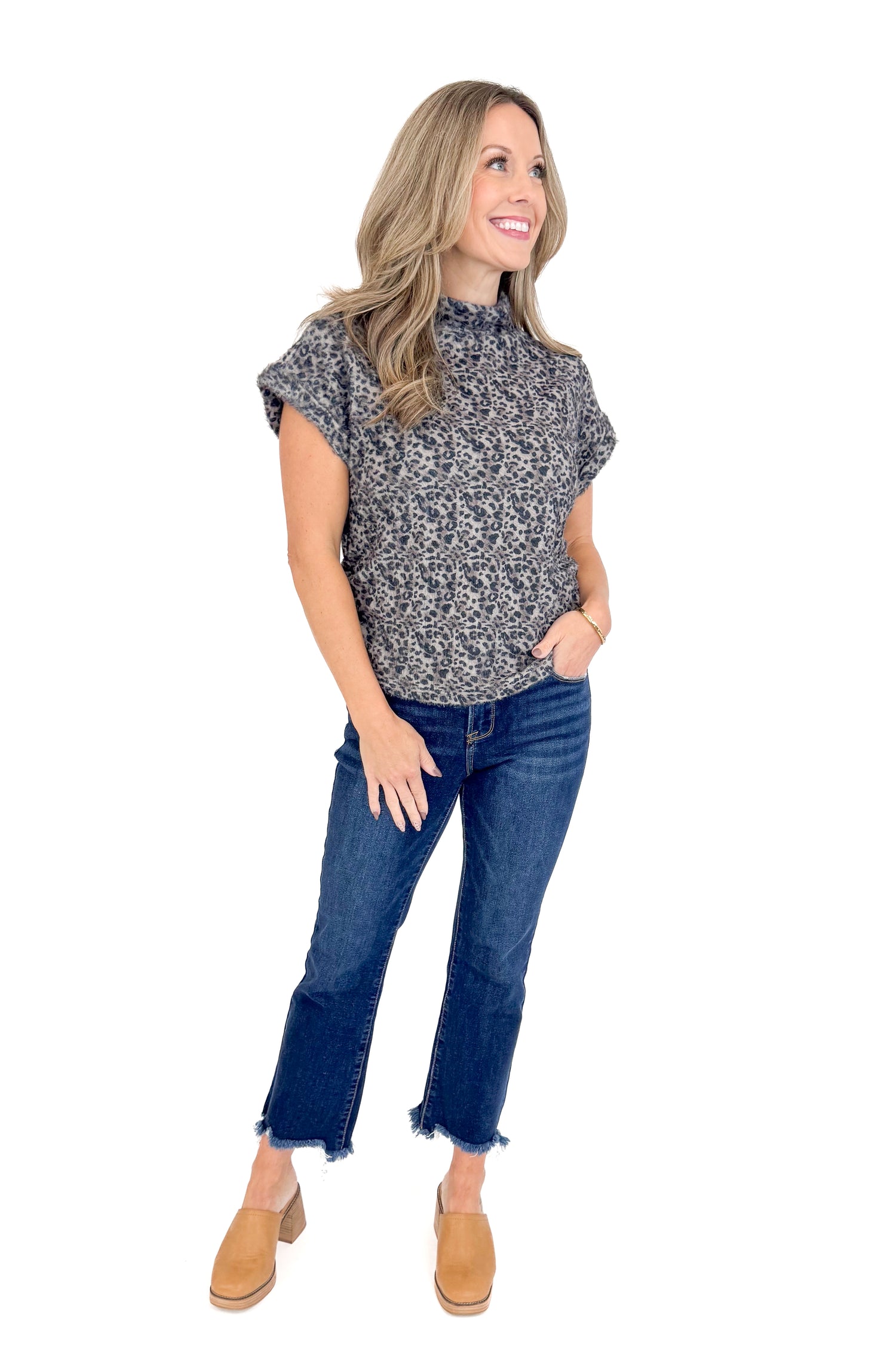 Front view of woman wearing Grey Leopard Short Sleeve Fuzzy Top and blue jeans.