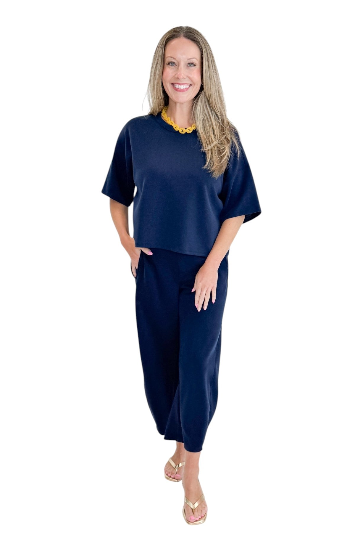Front view of woman wearing Swagger Boutiqueās Navy barrel pants with Navy Round Neck Short Sleeve Top against white studio background.