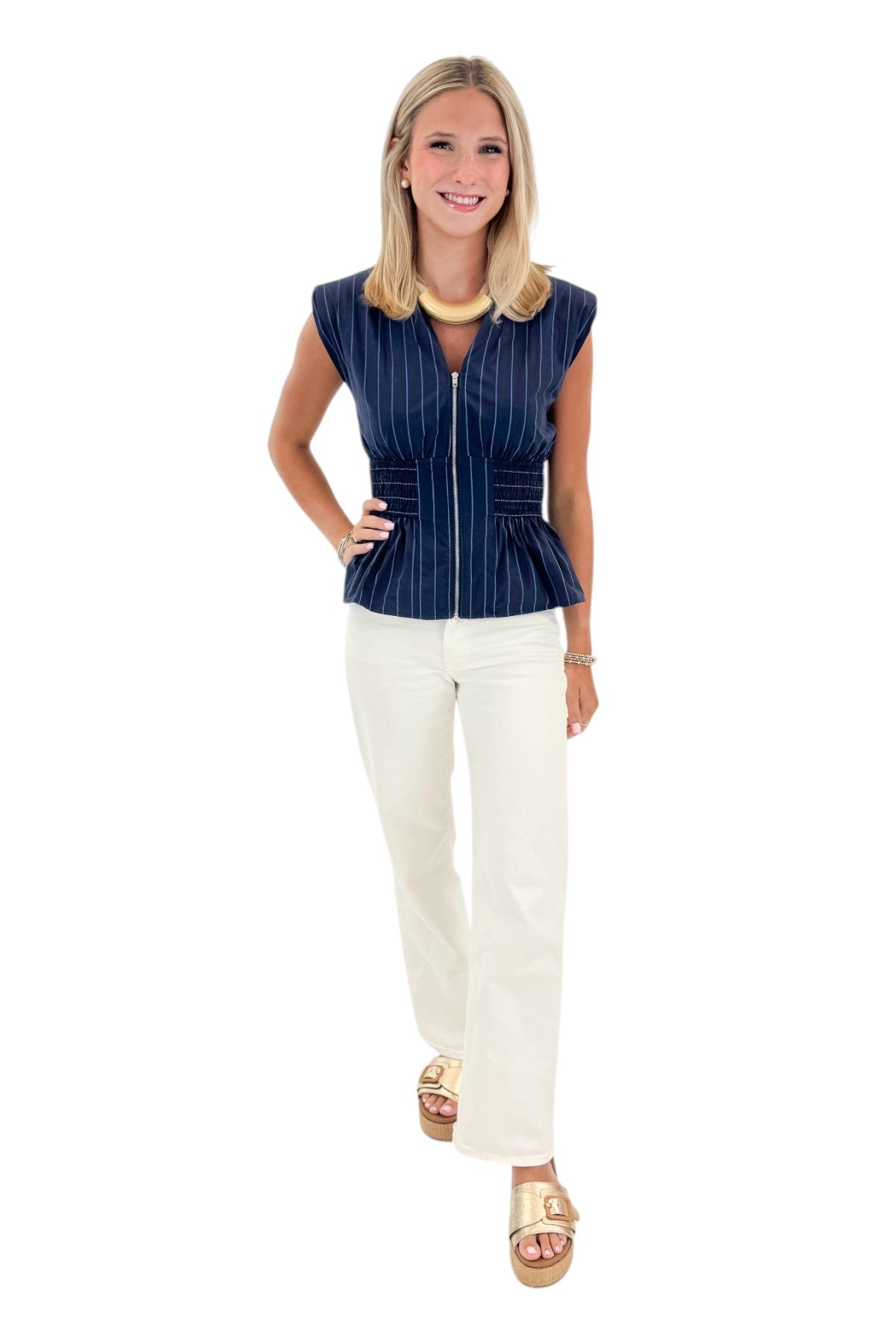 Front view of woman wearing Swagger Boutique’s Navy Striped Peplum Tank with jeans against white studio background.