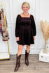 Woman wearing Brown Corduroy Puff Sleeve Dress and boots with decor in background.