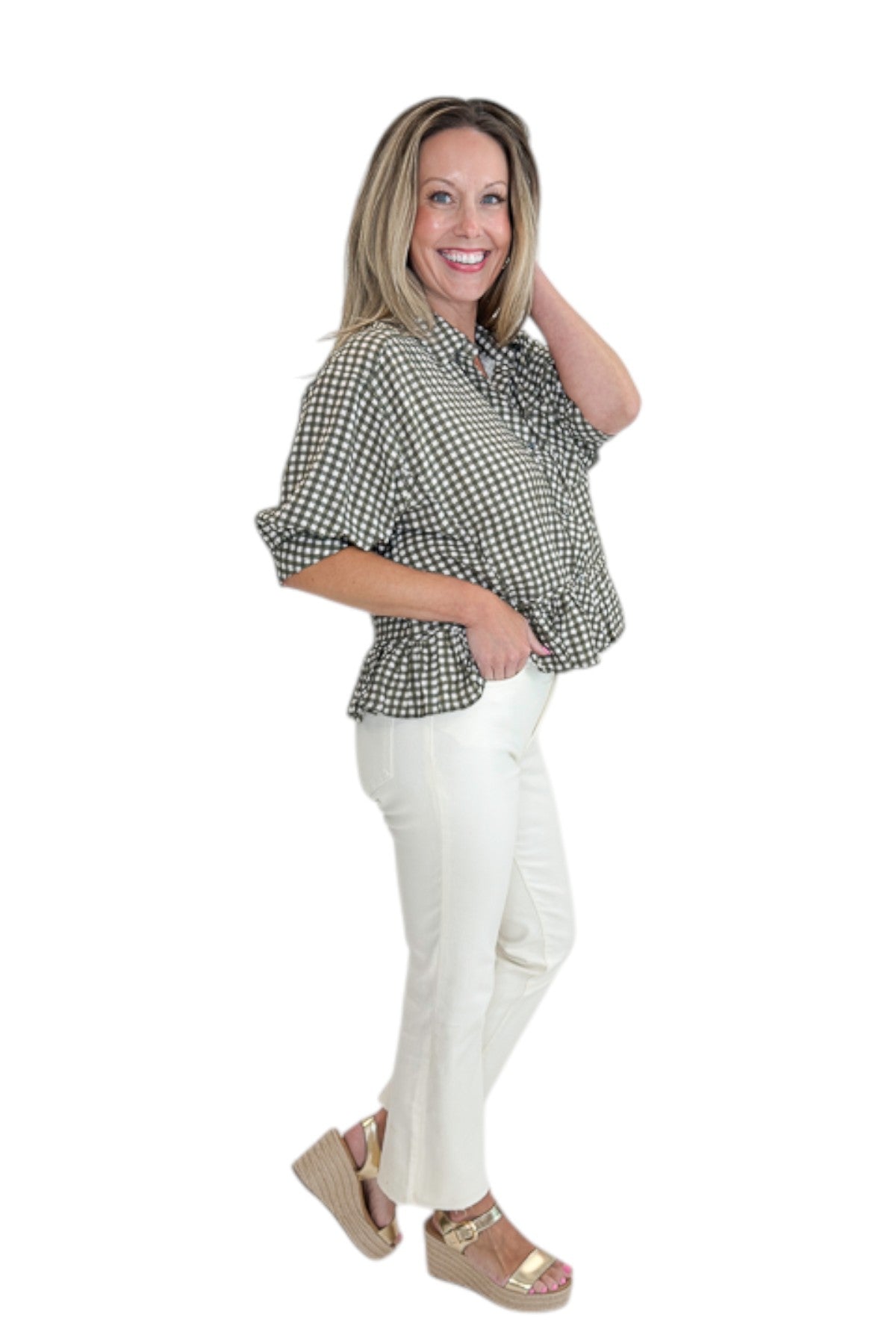Side view of woman wearing Swagger Boutiqueβs Olive Gingham Peplum Top by Entro with jeans against white studio background.
