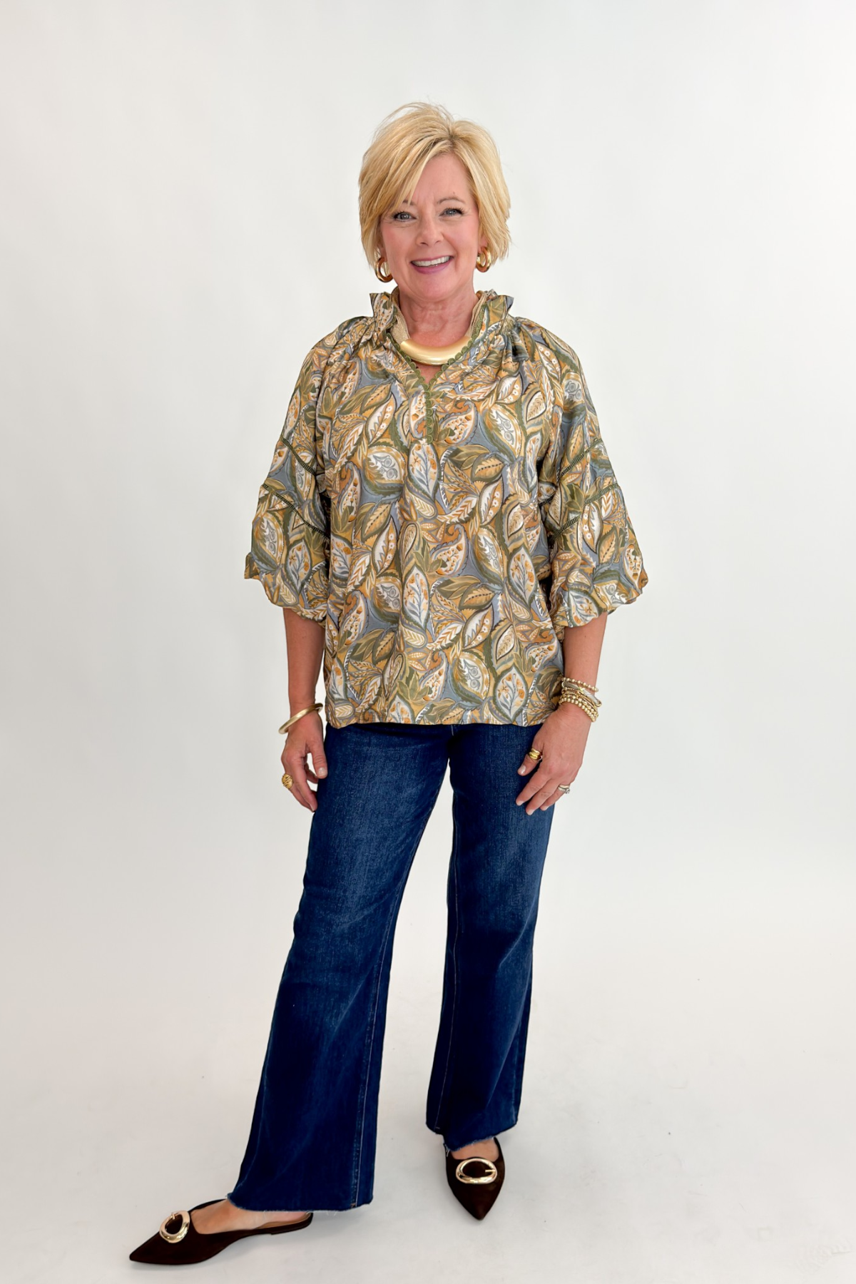 Front view of woman wearing Swagger Boutique’s Olive Printed 3/4 Sleeve Top with jeans against white studio background.