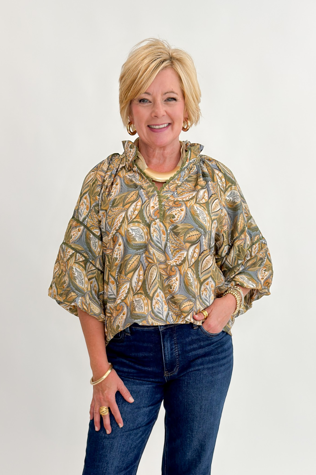 Front view of woman wearing Swagger Boutique’s Olive Printed 3/4 Sleeve Top with jeans against white studio background.