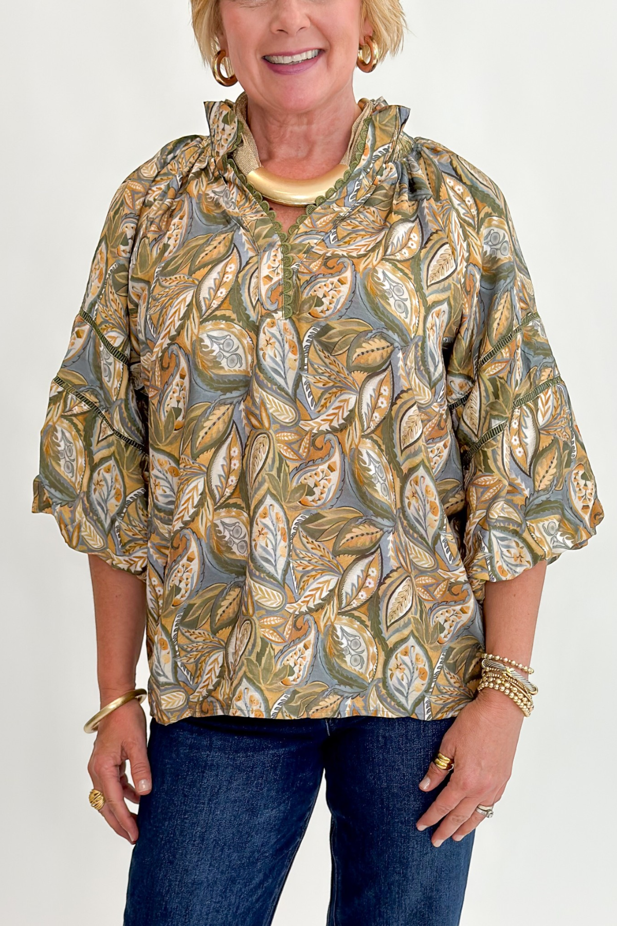 Front detail view of woman wearing Swagger Boutique’s Olive Printed 3/4 Sleeve Top with jeans against white studio background.