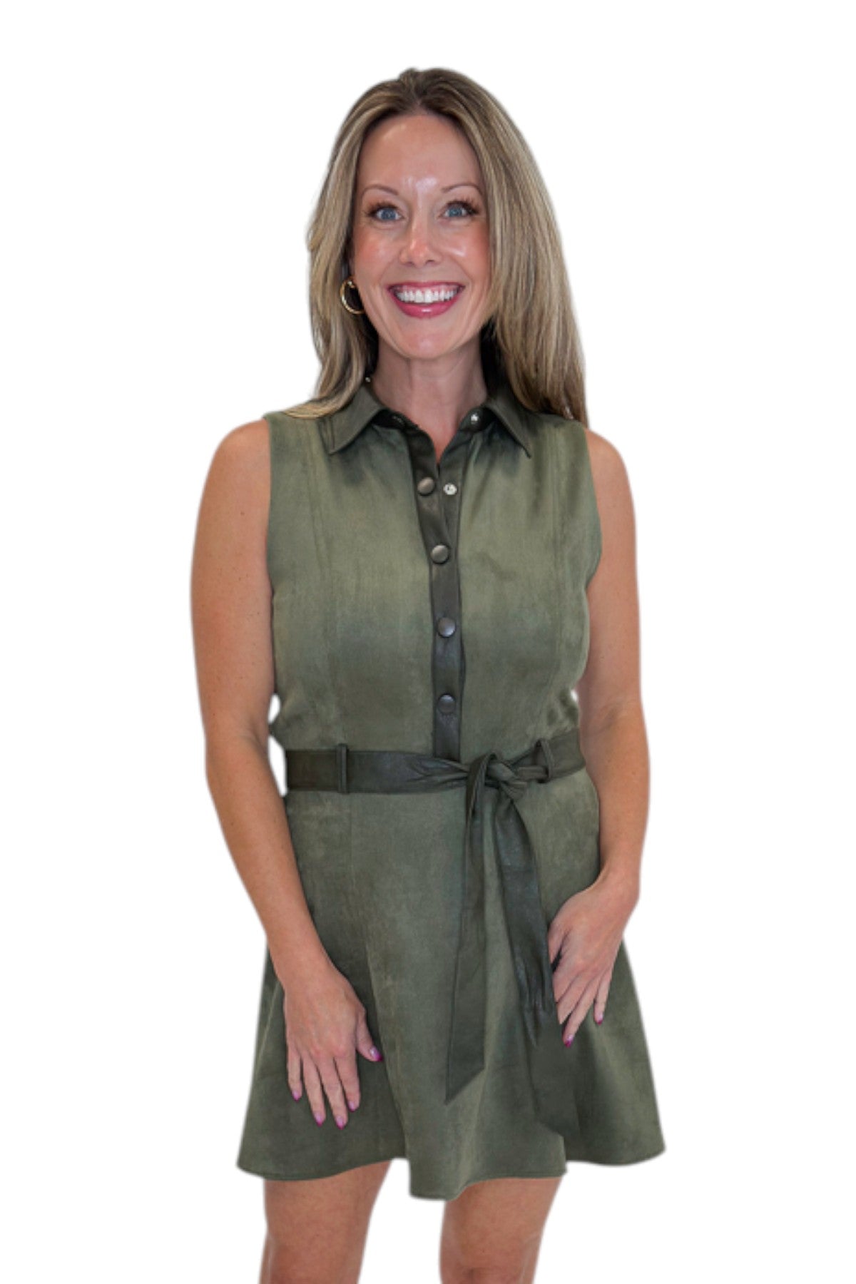 Front view of woman wearing Swagger Boutiqueโs Olive Suede Mini Dress with heels against white studio background.