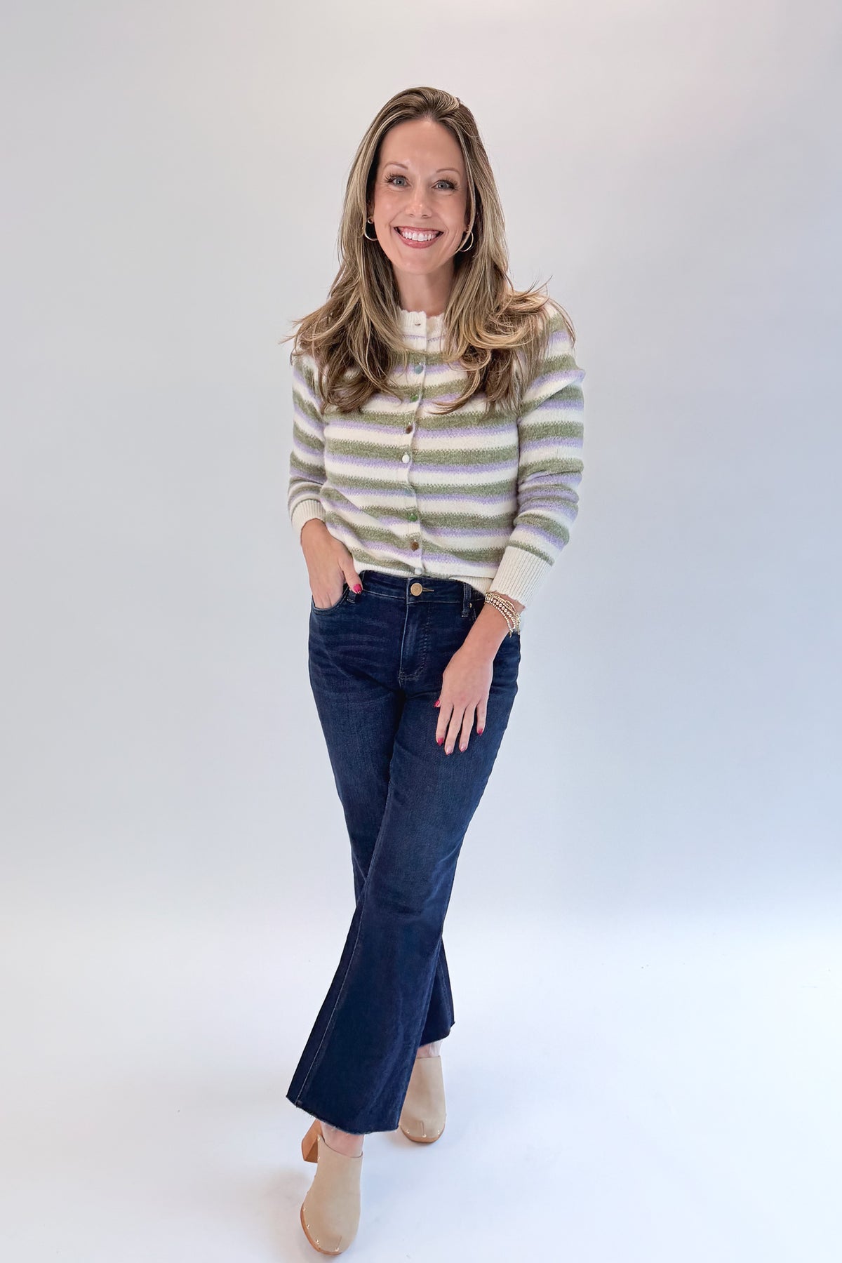 Front view of woman wearing Swagger Boutique’s Olive & Lavendar Striped Button Up Cardigan with jeans against white studio background.