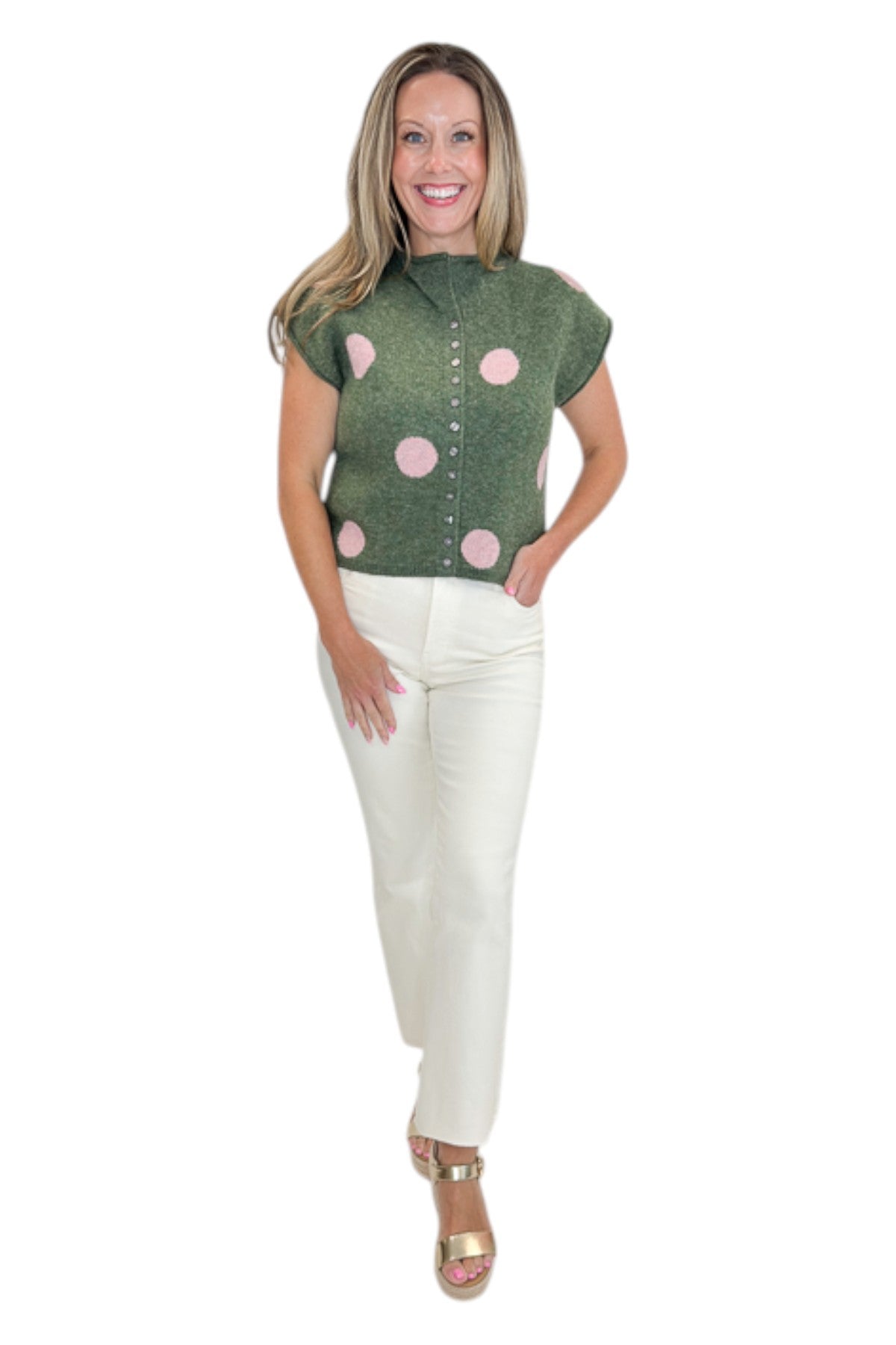 Front view of woman wearing Swagger Boutiqueβs Olive & Pink Polka Dot Sleeveless Button Up Sweater by Entro with jeans against white studio background.