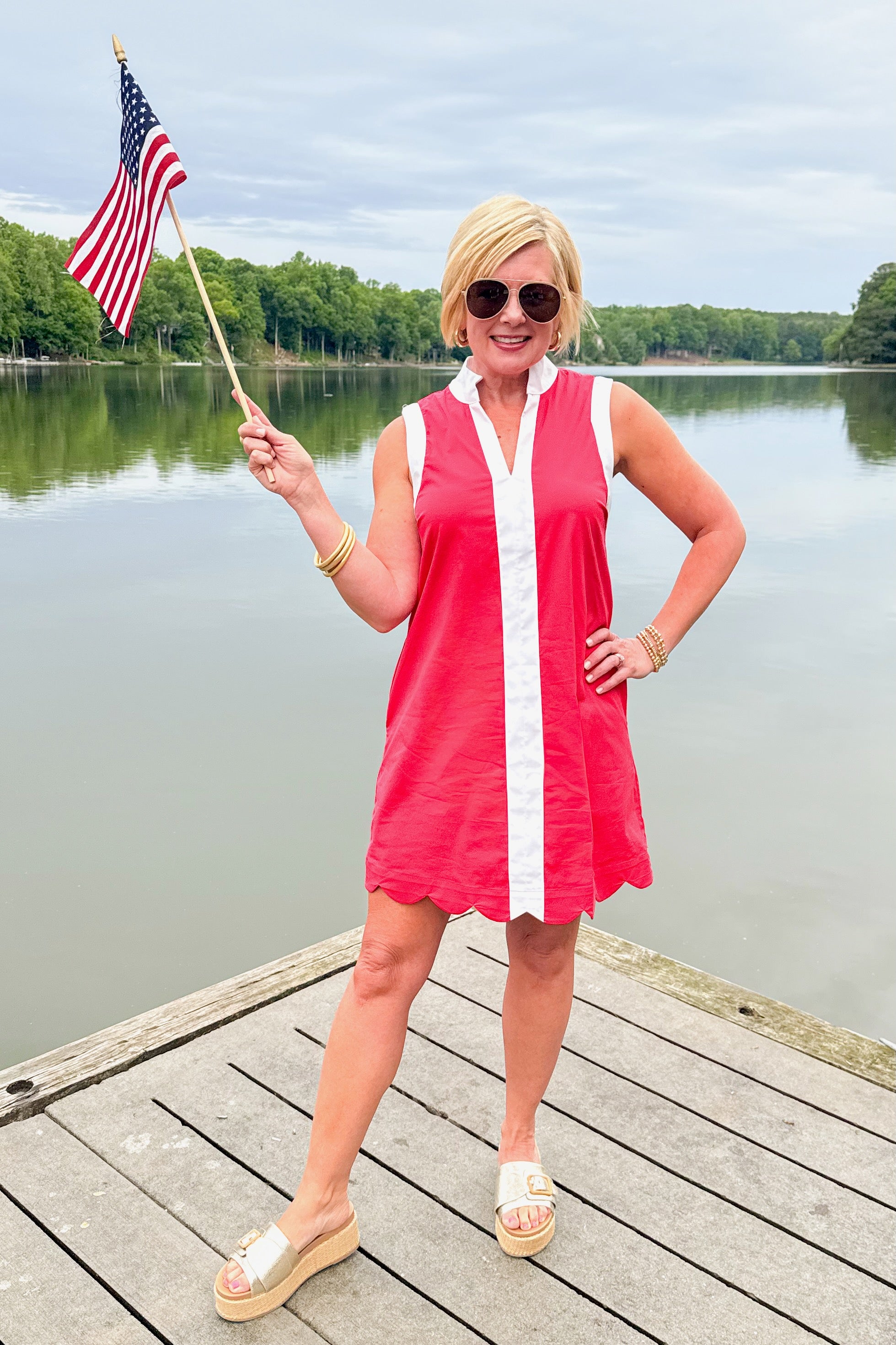 Front view of woman wearing Red With Center Stripe Scallop Hem Dress by Entro and Lulah sandals outside at the lake.