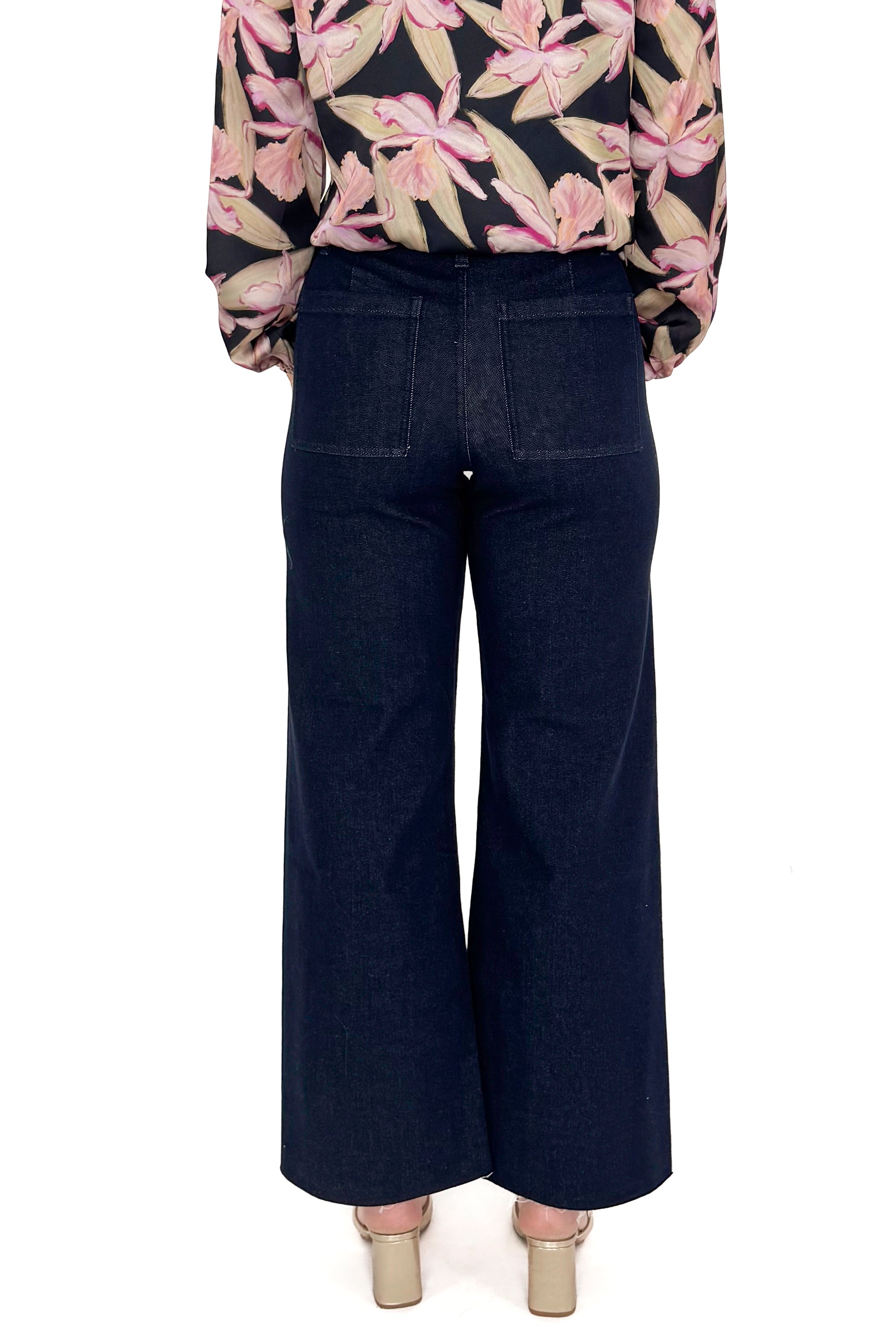 Back view of woman in a studio wearing Dark Indigo Wide Leg Jeans and print top with a white background.