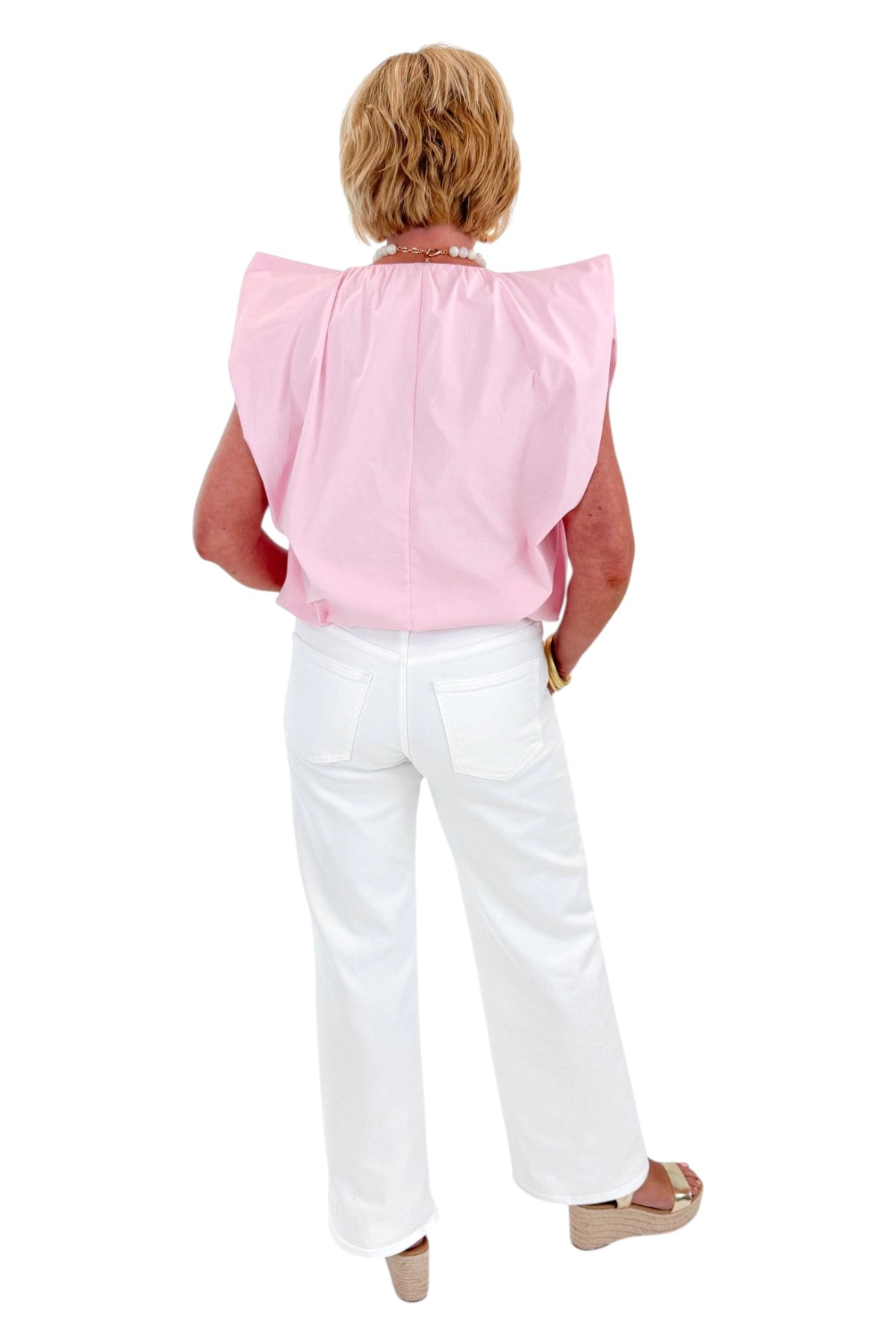 Back view of woman wearing Swagger Boutiqueās Pink Bubble Hem Pleated Top with jeans against white studio background.