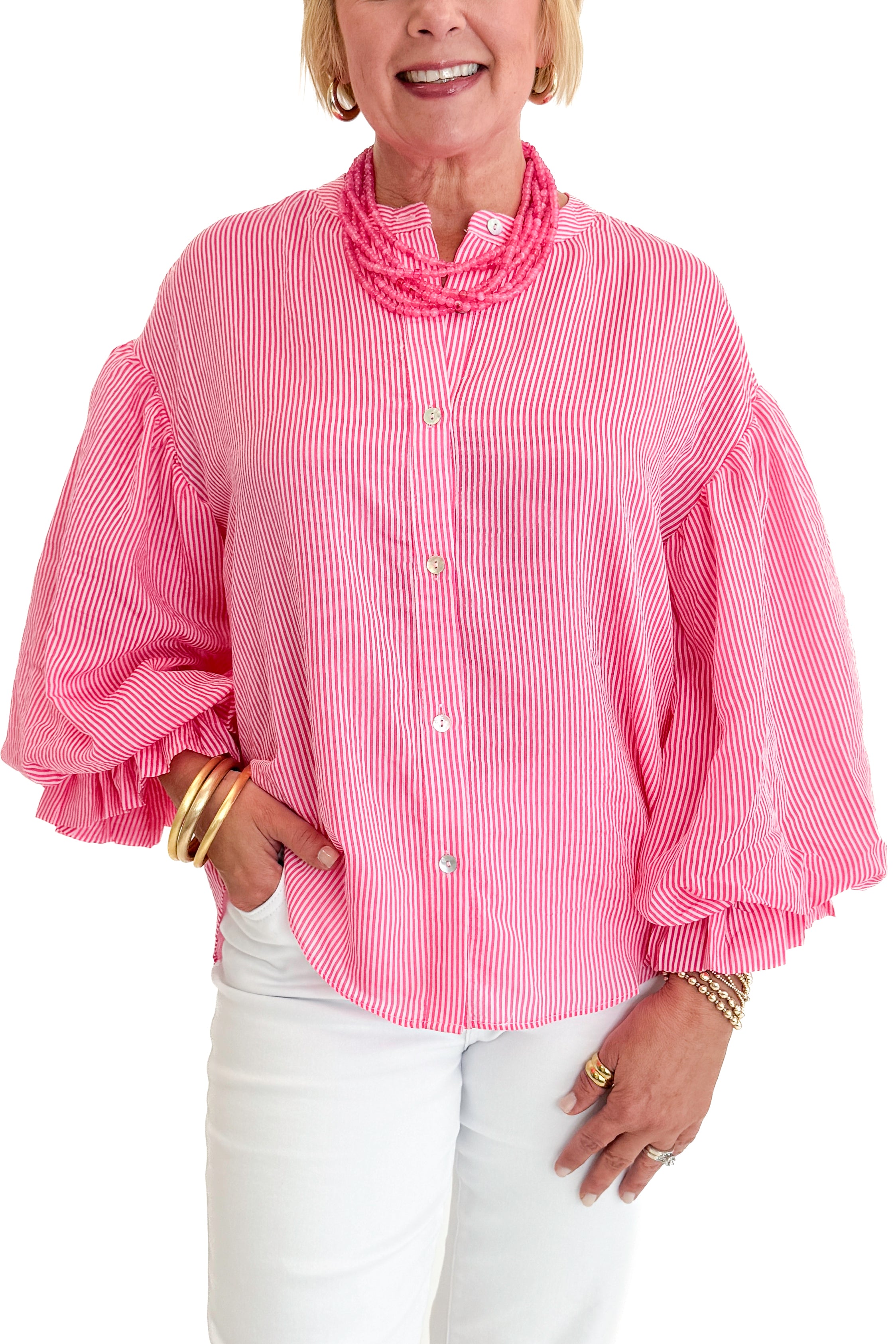 Front detail view of woman wearing Swagger Boutiqueβs Pink Pinstripe Bubble Sleeve Top with jeans against white studio background.
