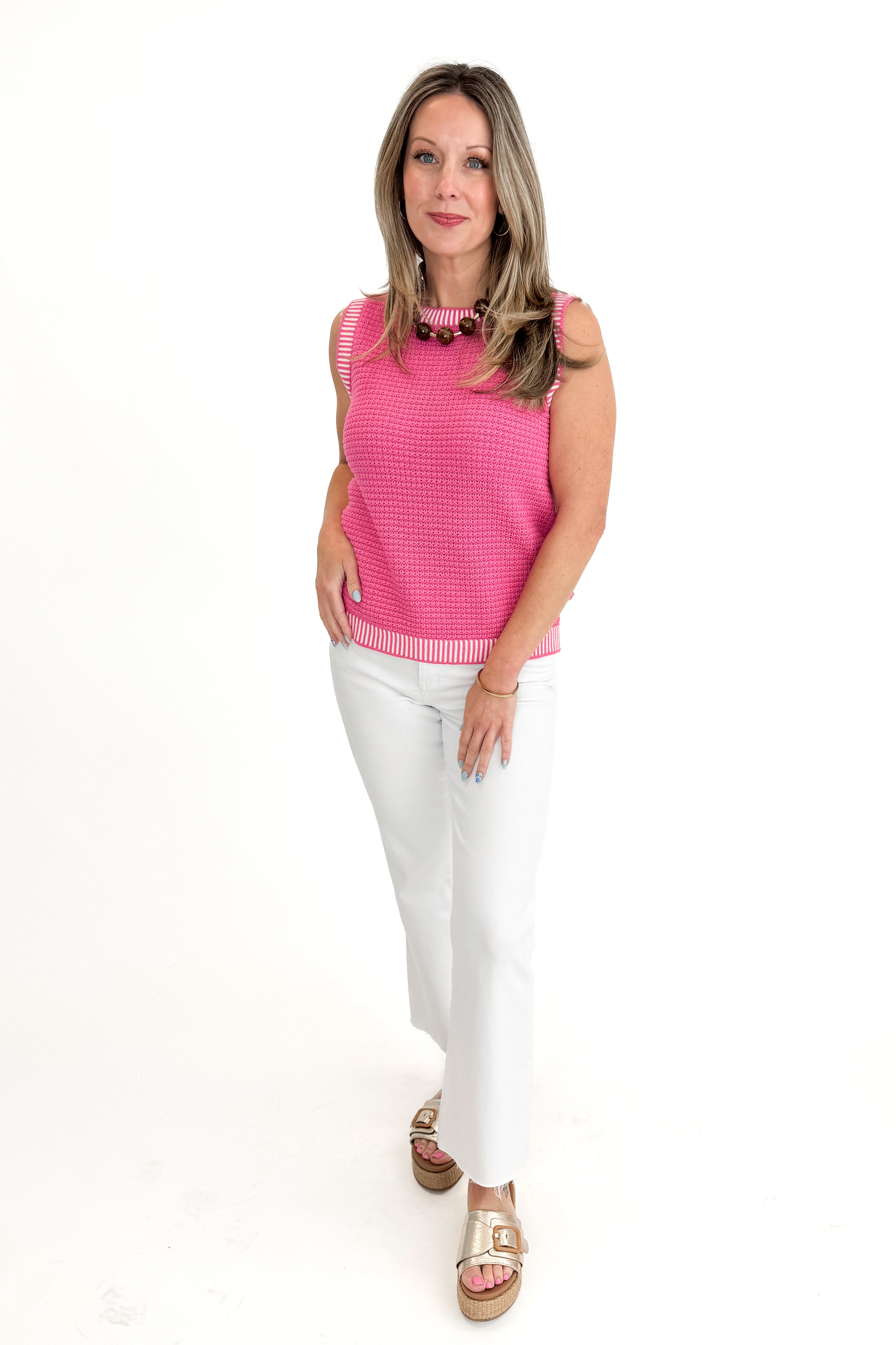 Front view of woman wearing Above All Else Pink & White Textured Sweater Tank with jeans against white studio background.