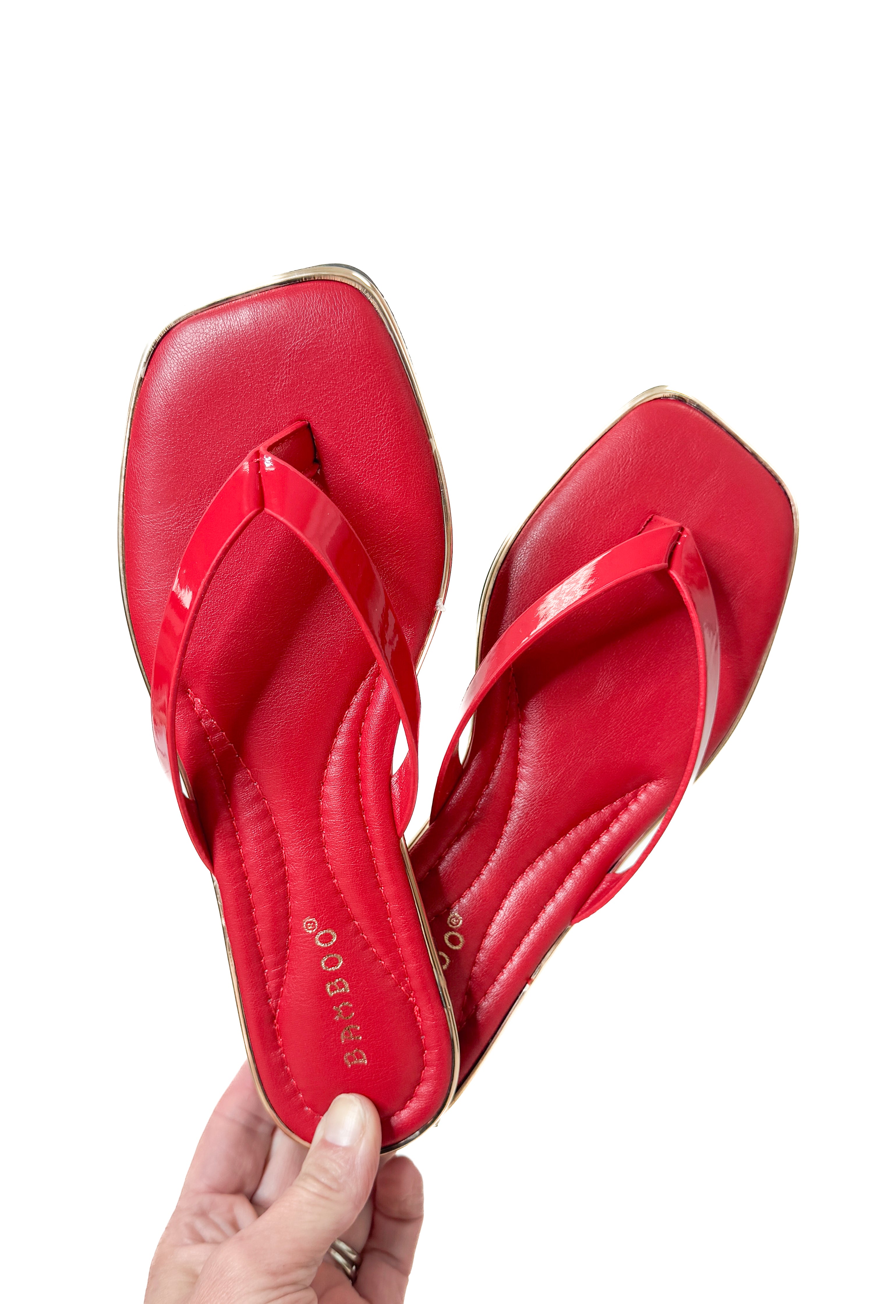 Pointer- Red Flip Flops against studio background.