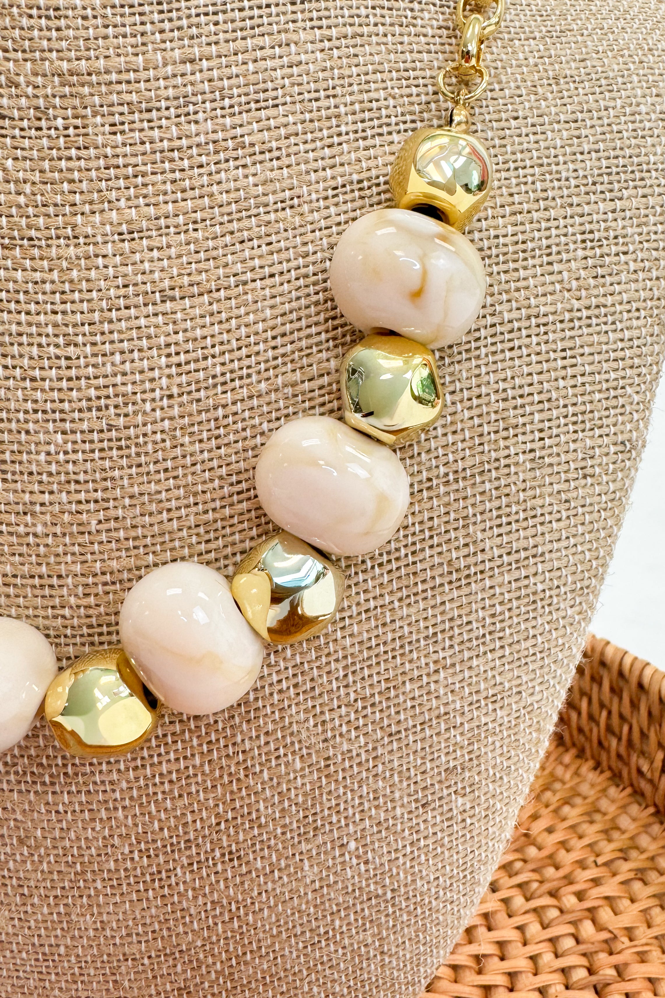 Bracelet with gold and white beads on a textured surface