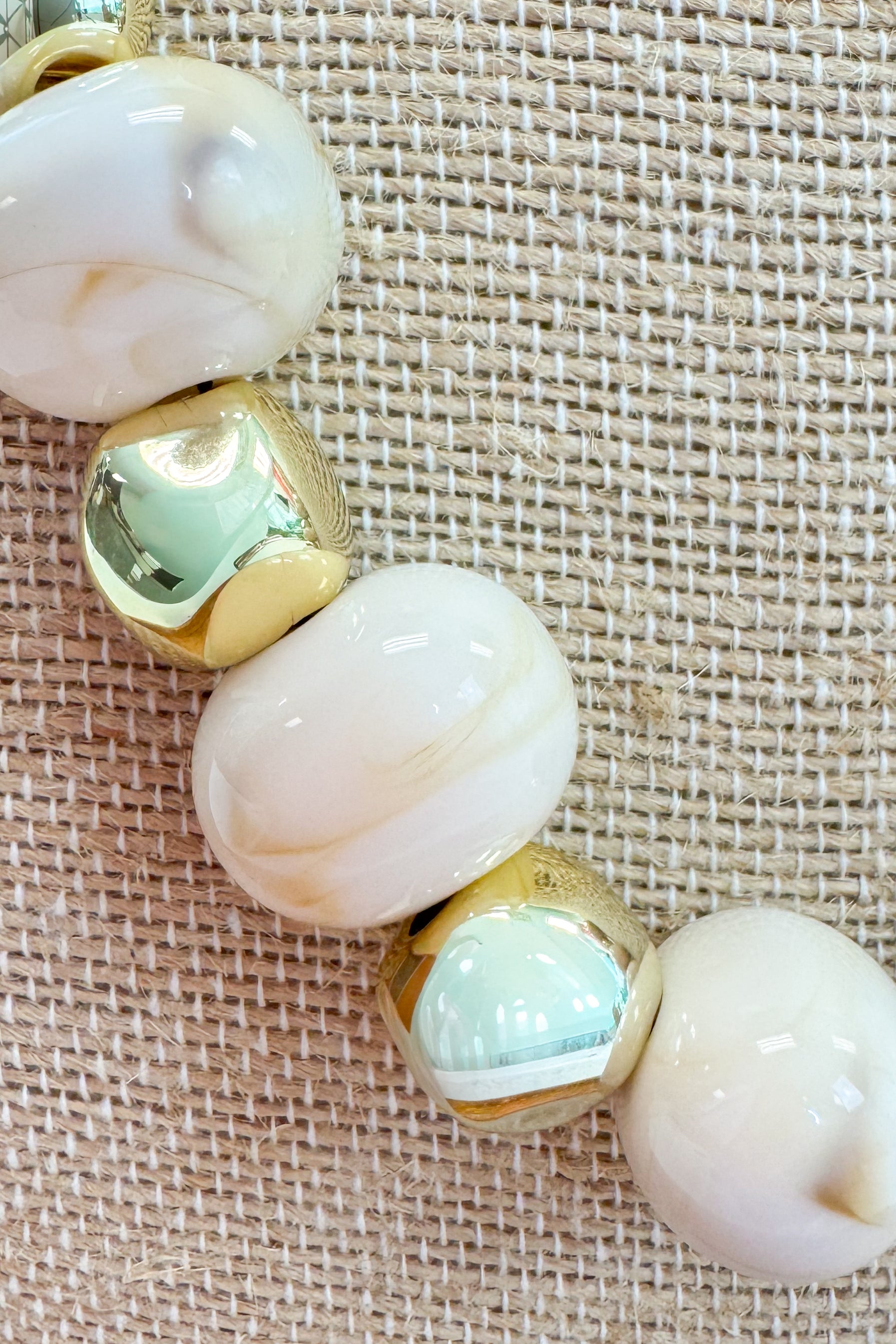 Necklace with large beads on a textured beige background