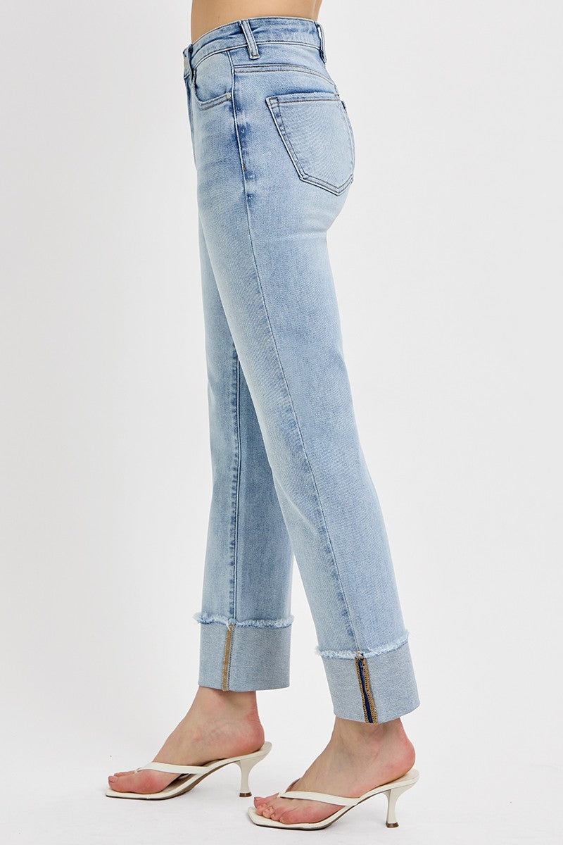 Side view of woman wearing sweater with Light Wash Relaxed Straight Jeans by Risen against white studio background.