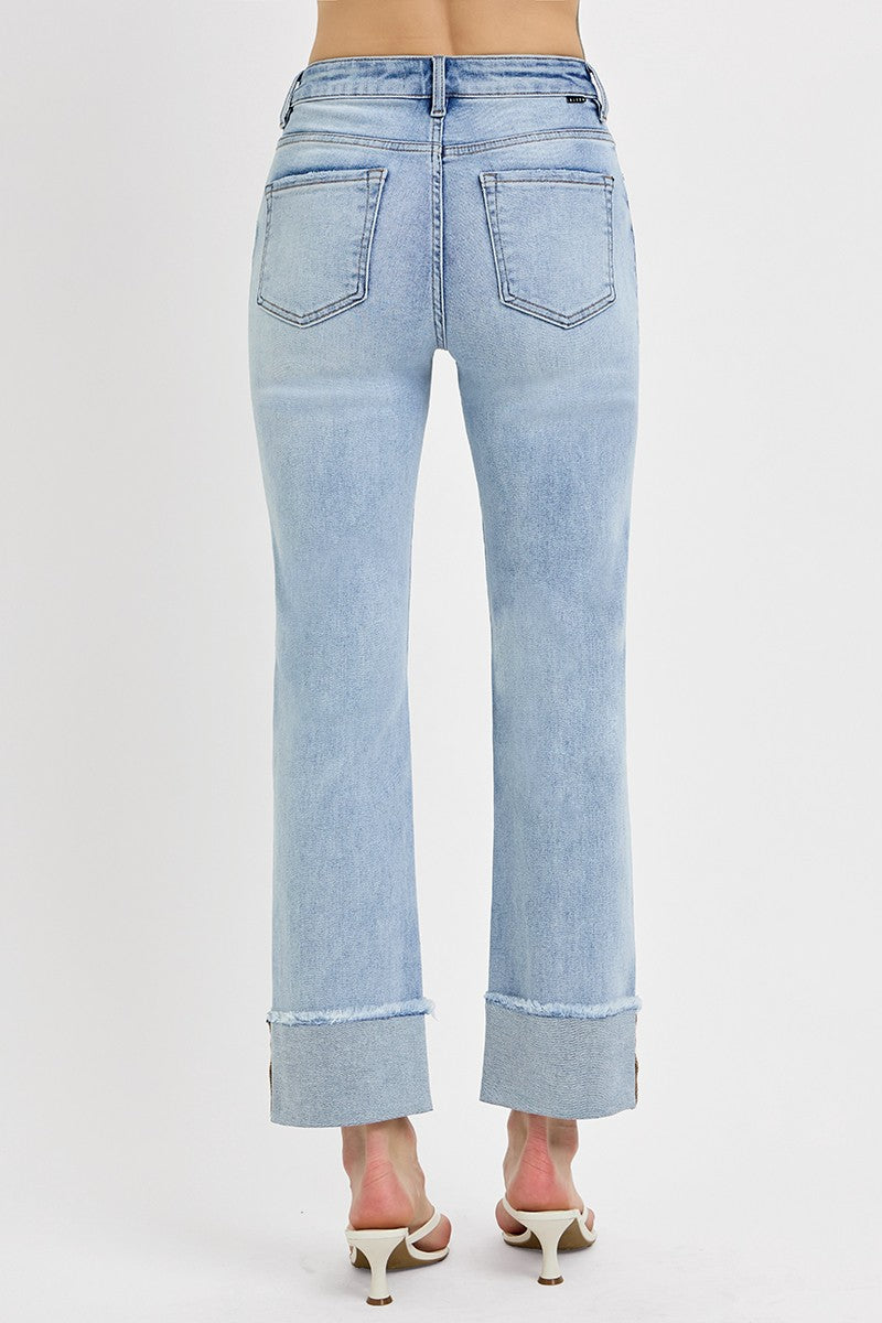 Back view of woman wearing sweater with Light Wash Relaxed Straight Jeans by Risen against white studio background.