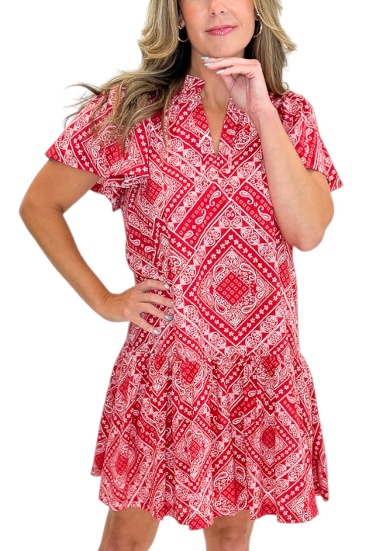 Front details view of woman wearing Swagger Boutiqueās Red Bandana Print Mini Dress with sandals against white studio background.