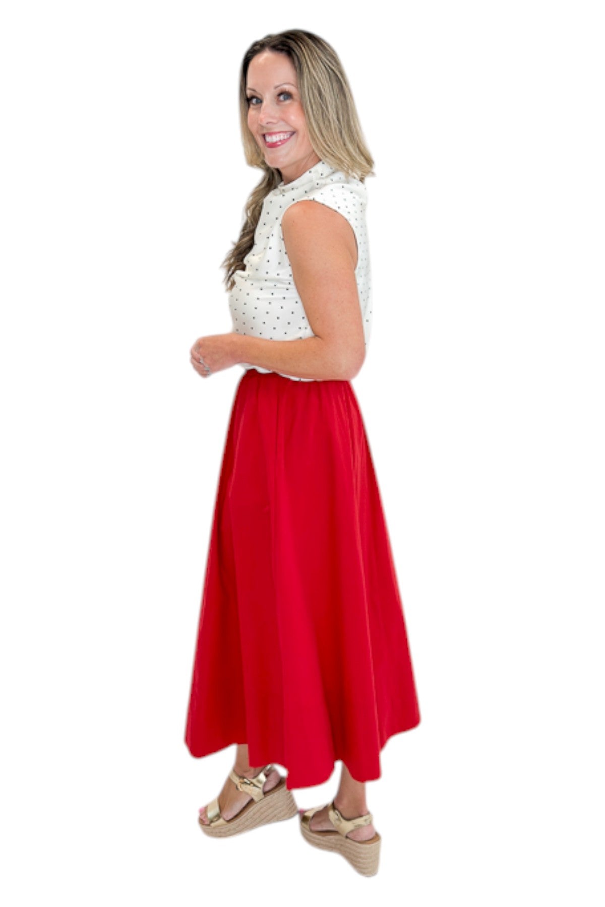 Side view of woman wearing Swagger Boutiqueās Red Elastic Waist Midi Skirt with sandals against white studio background.