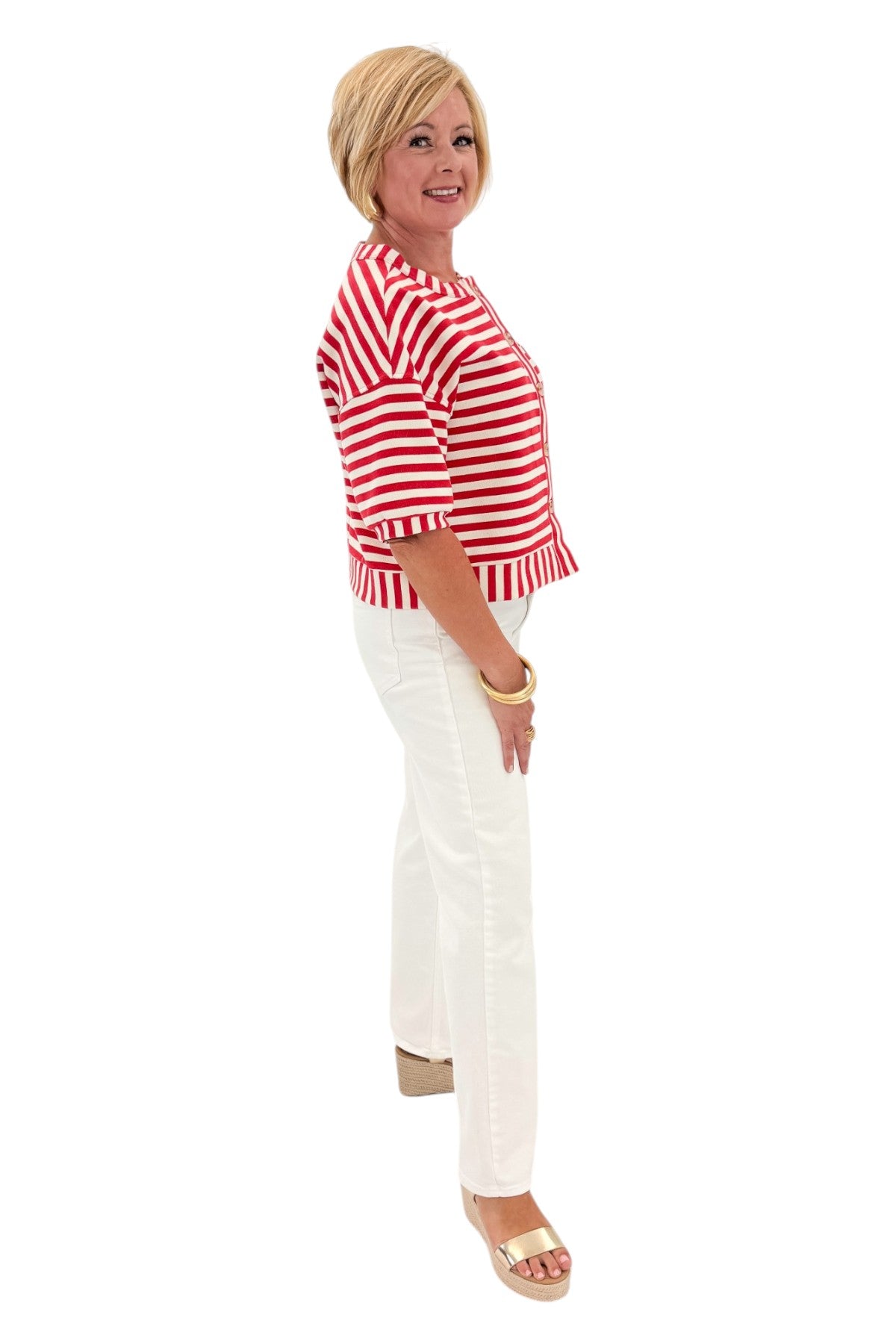 Side view of woman wearing Swagger Boutique’s Red Striped Short Sleeve Button Up Top with jeans against white studio background.