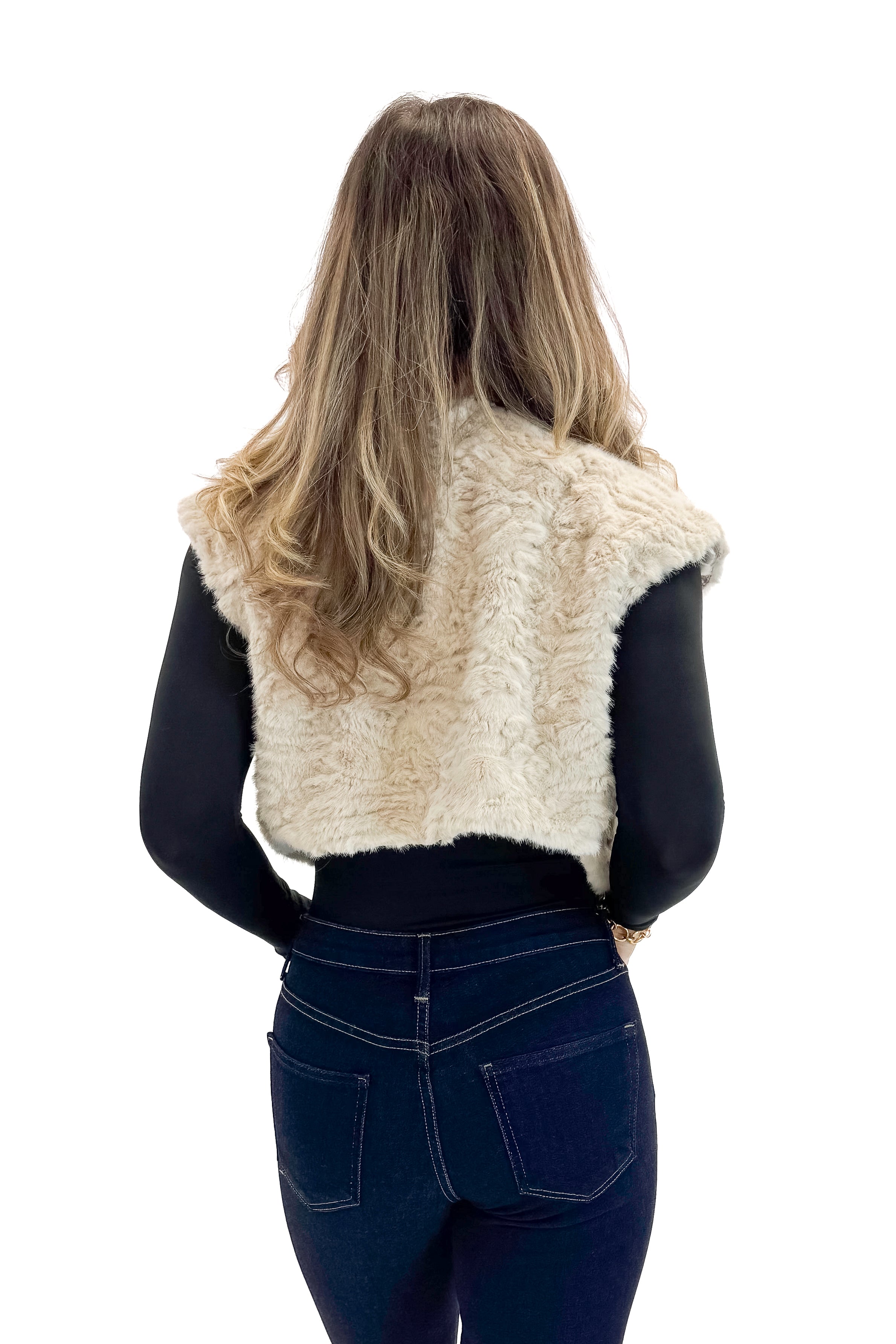 Back view of woman wearing Taupe Cropped Faux Fur Vest with jeans against white studio background.
