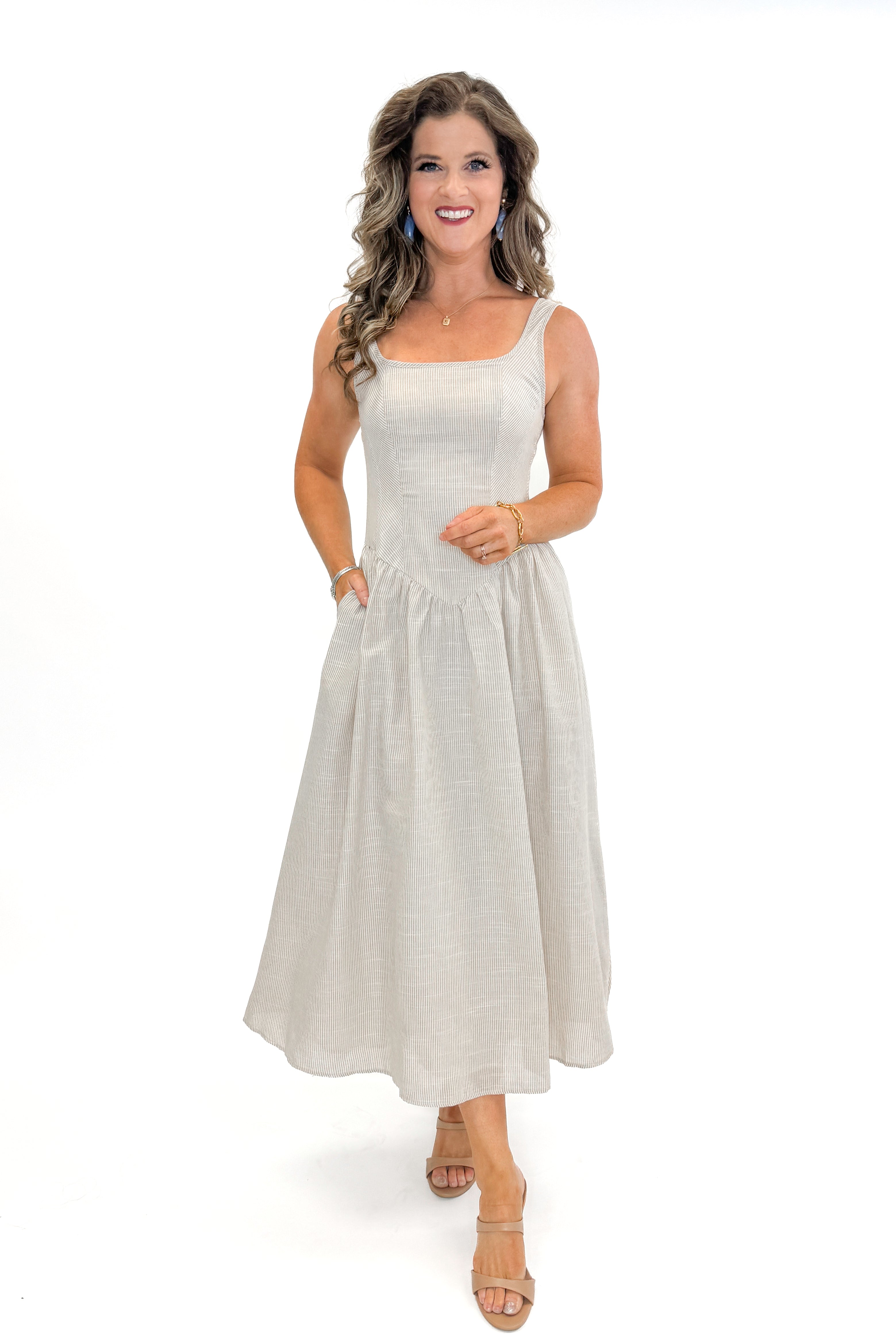 Front view of woman wearing Taupe Striped V-Waist Dress against white studio background.