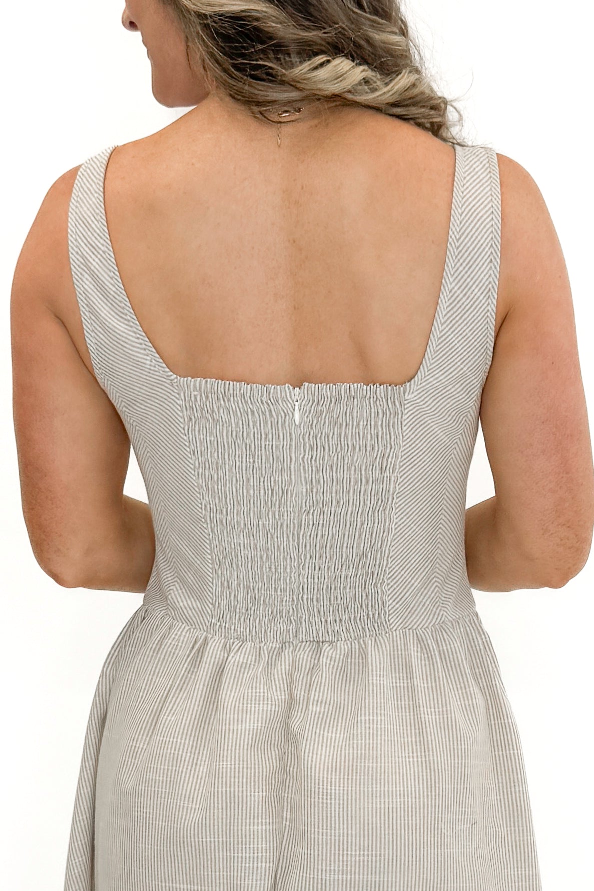 Back detail view of woman wearing Taupe Striped V-Waist Dress against white studio background.