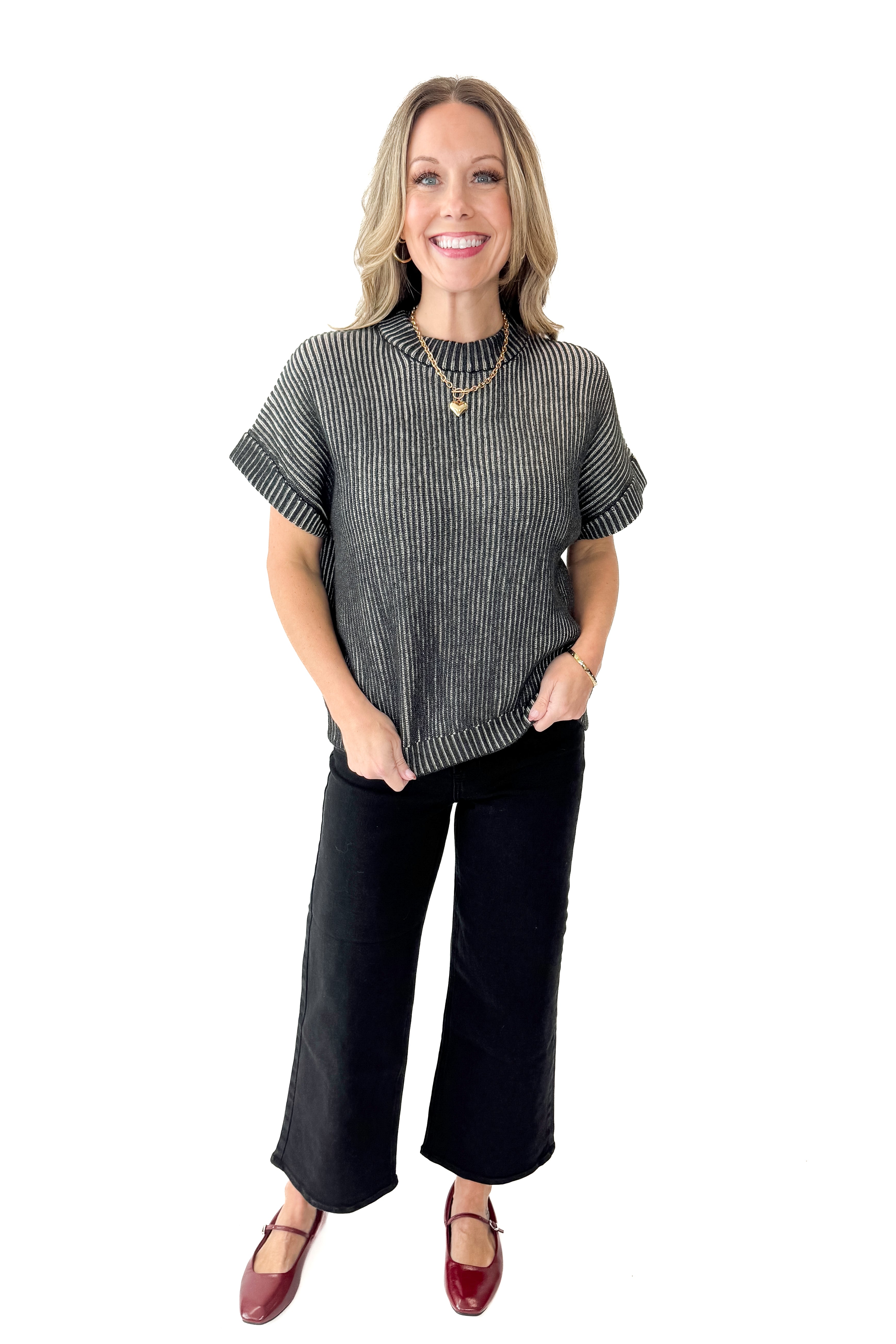 Front view of woman wearing Black & White Ribbed Short Sleeve Sweater with jeans against white studio background.