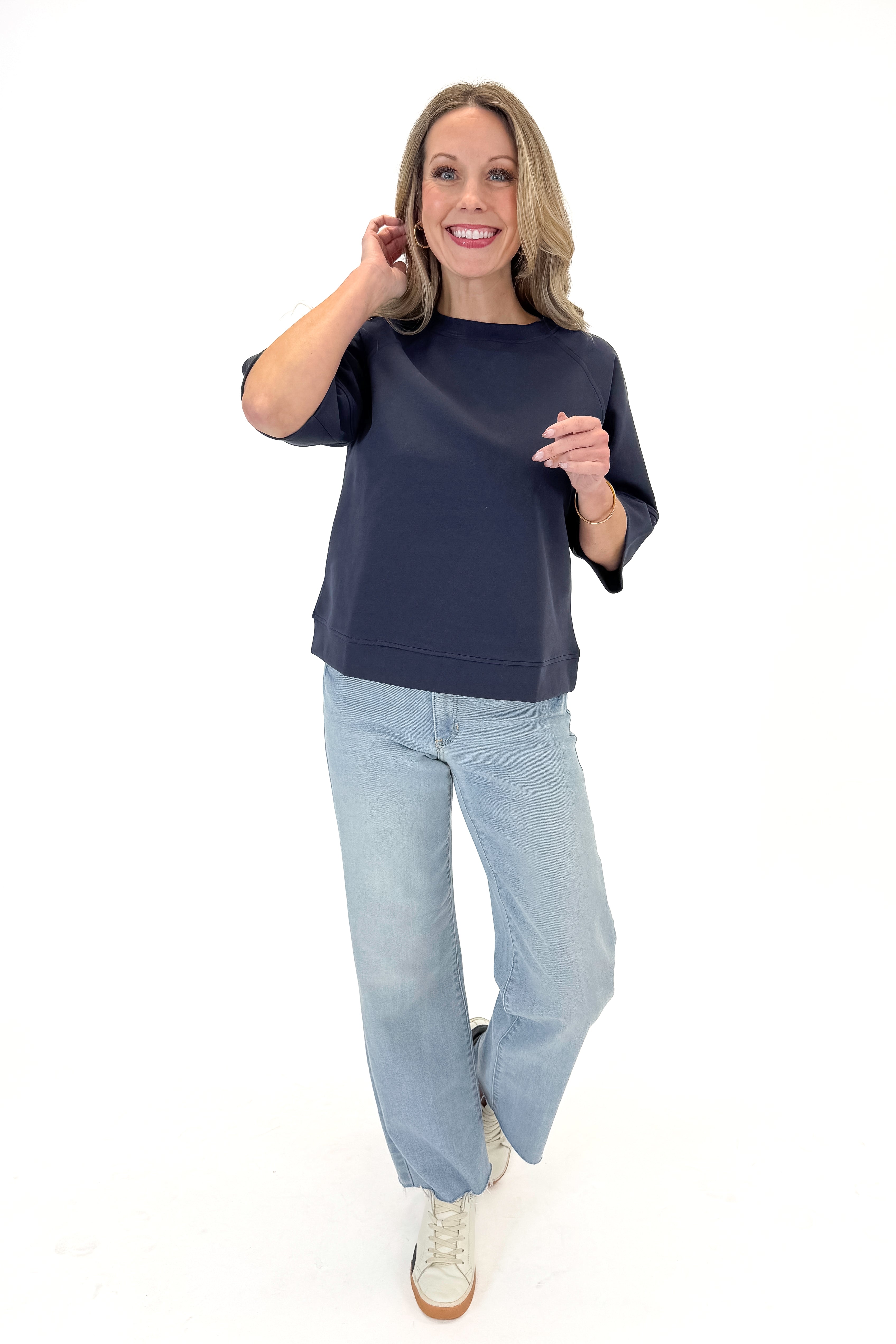 Front view of woman wearing Navy Super Soft Half Sleeve Top with jeans against white studio background.
