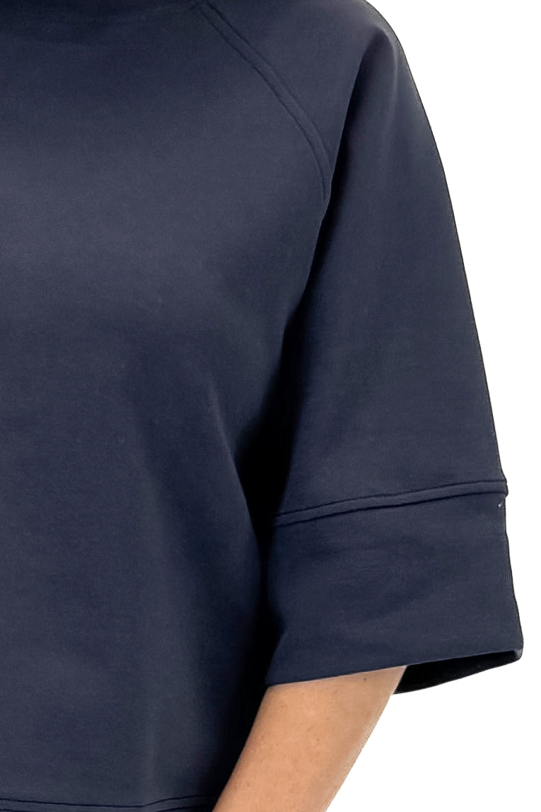 Front detail view of woman wearing Navy Super Soft Half Sleeve Top against white studio background.