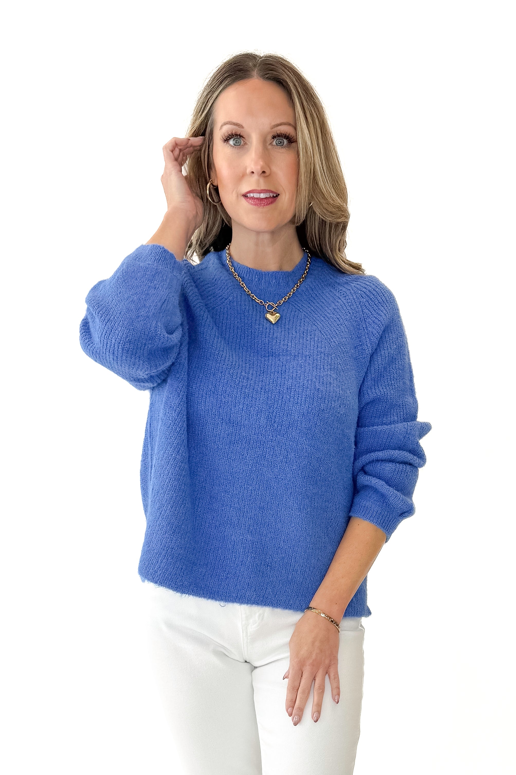 Front view of woman wearing Blue Ribbed Sweater with jeans against white studio background.