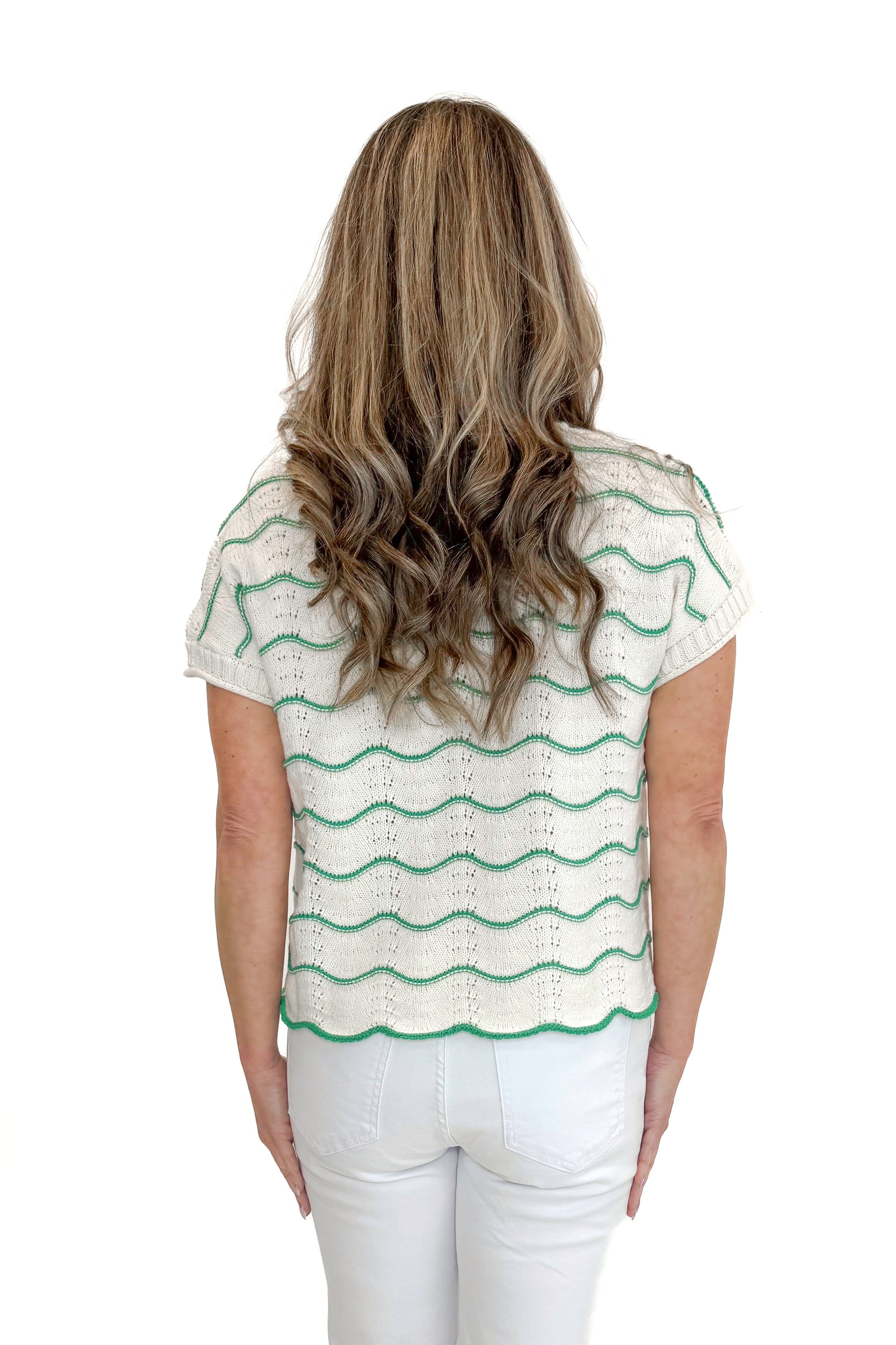 Back view of woman wearing Green & Cream Scallop Detail Short Sleeve Sweater with jeans against white studio background.