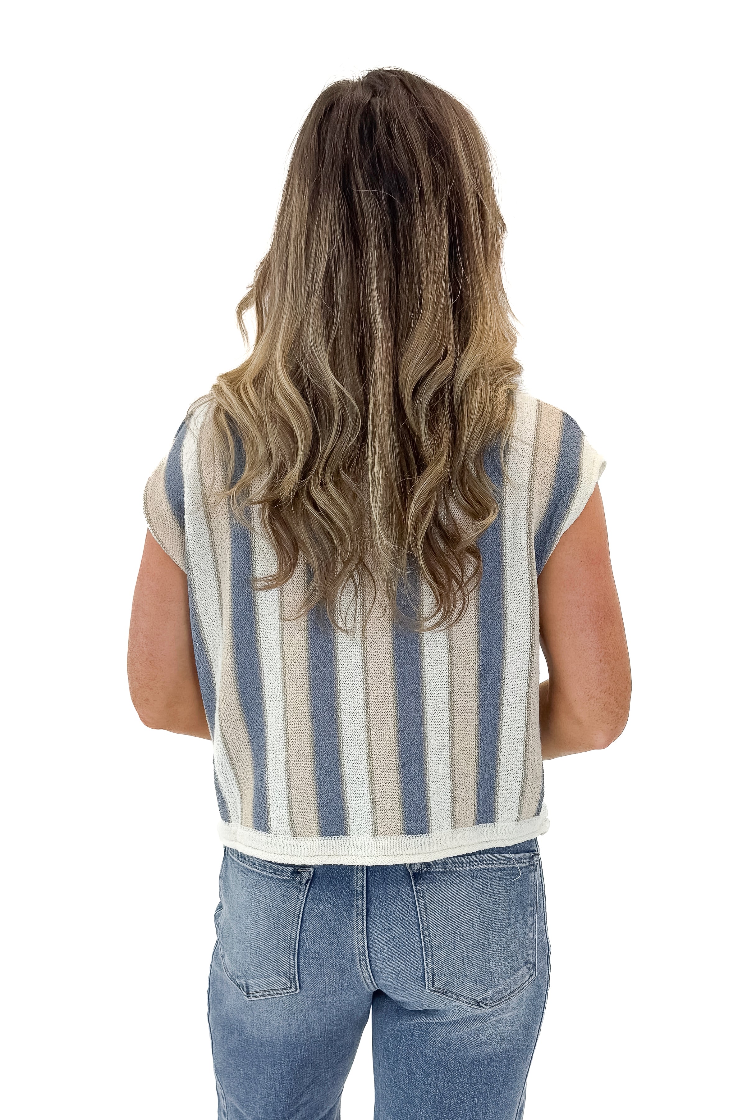 Back view of woman wearing Blue & Tan Striped Short Sleeve Sweater with jeans against white studio background.