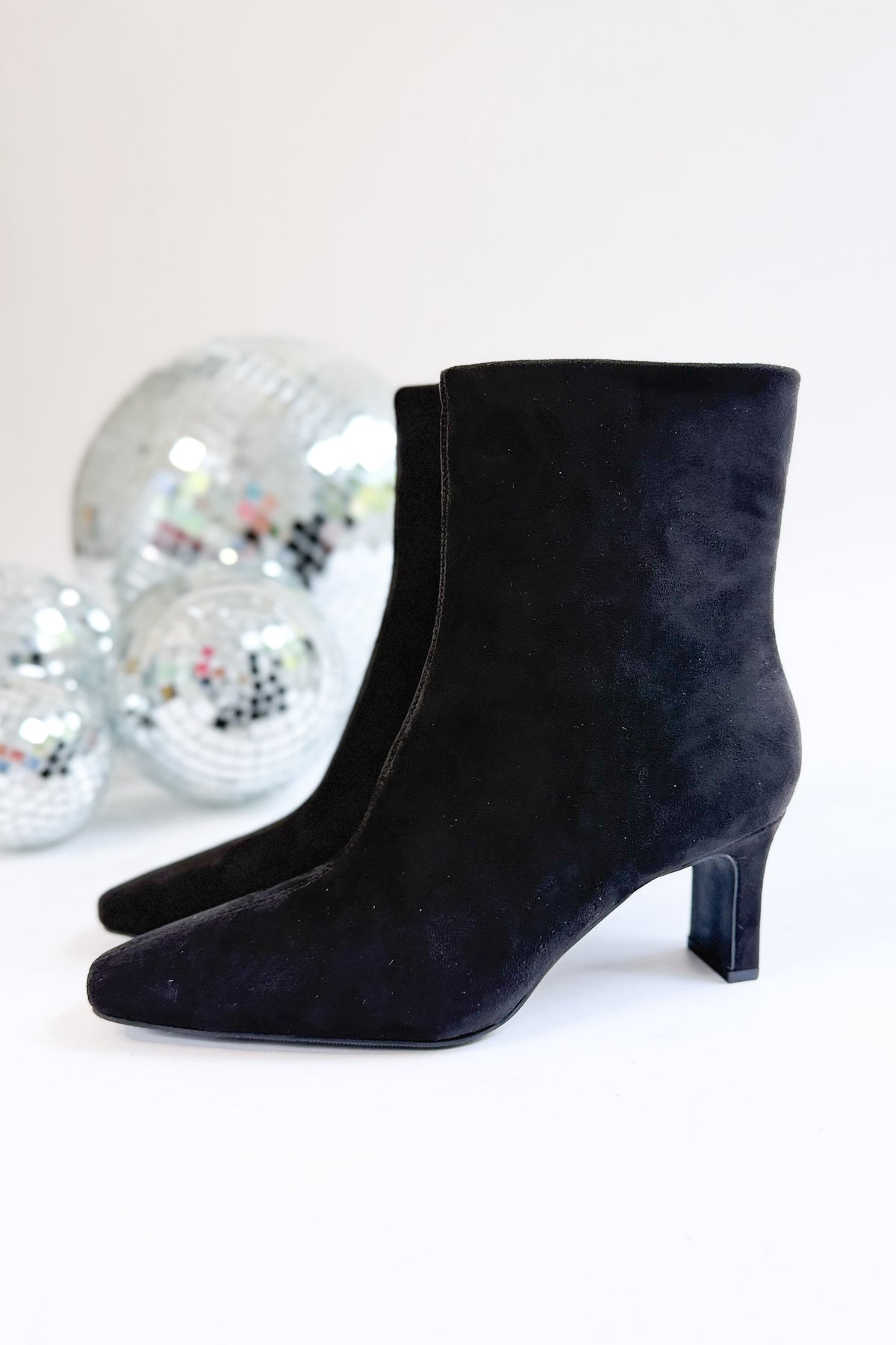 Swan- Black Suede Booties side view against white studio background.