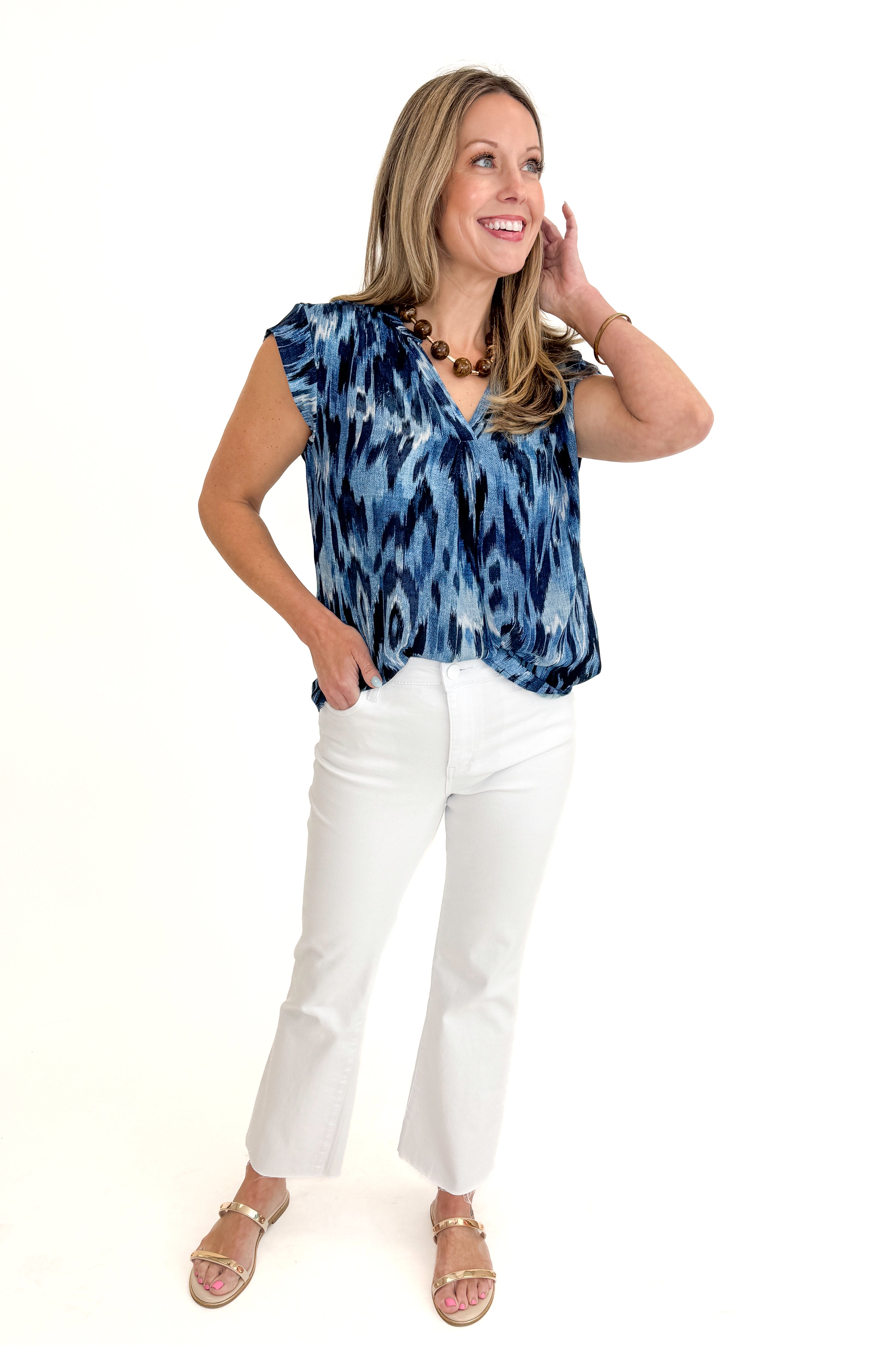 Front view of woman wearing Navy & Blue Printed V-Neck Top with jeans against white studio background.